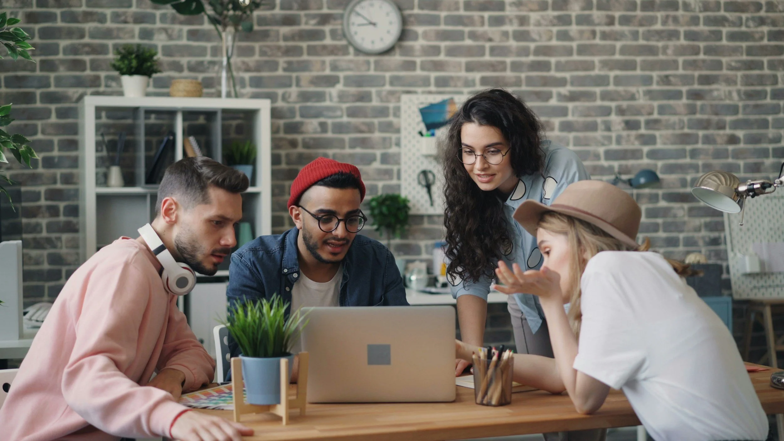 Team collaborating around a laptop, representing Urbanberry Recruitment’s people-first approach to travel recruitment.