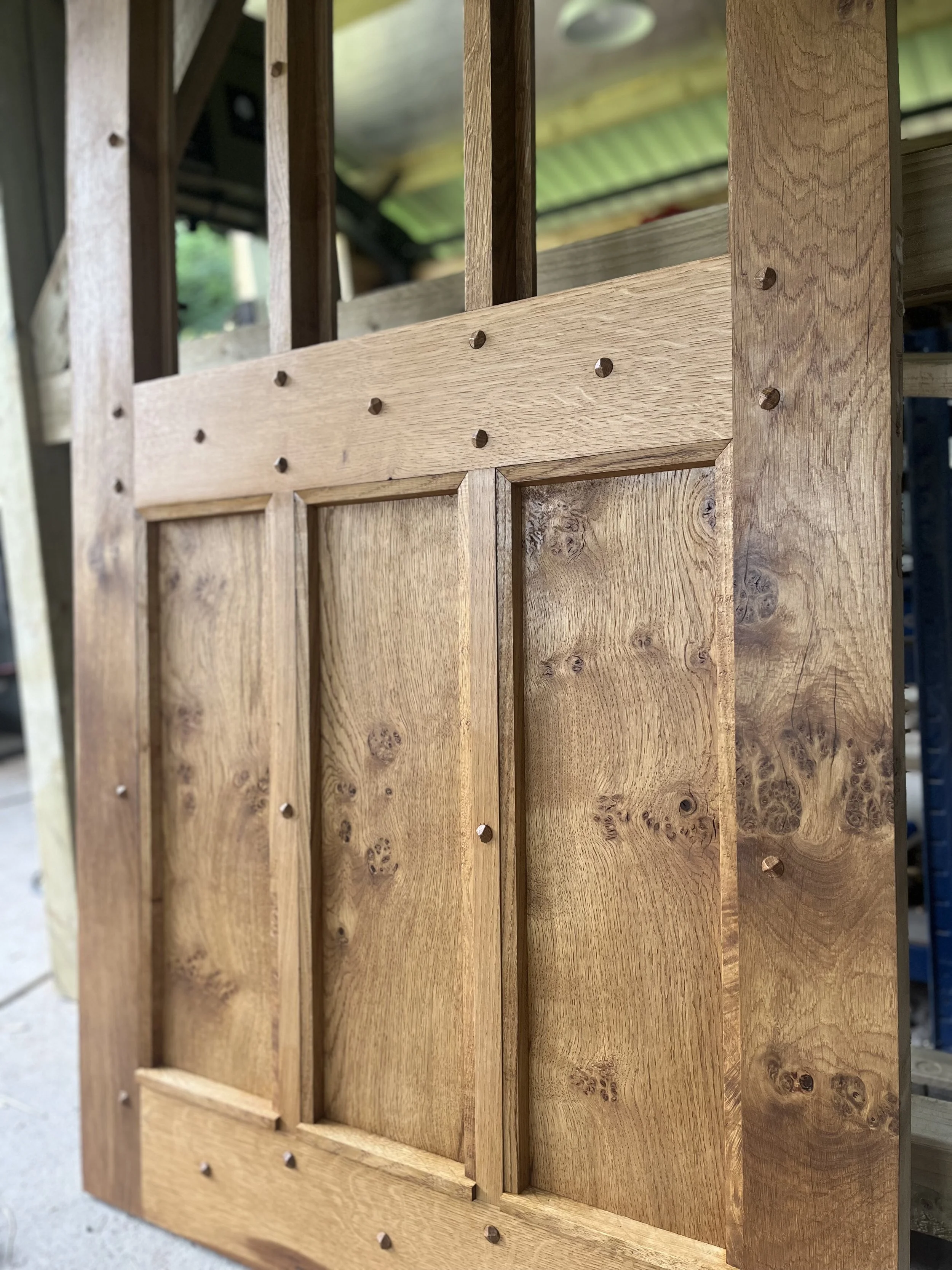 Close-up view of a wooden structure, possibly a part of furniture, with vertical and horizontal wooden panels fastened together with visible nails.