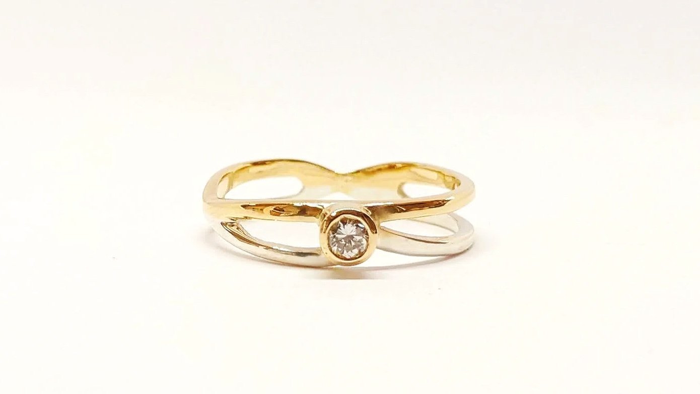 Union of engagement and wedding rings together with a special band inspired by a hand-written letter J. The original engagement diamond unites everything together at the centre.