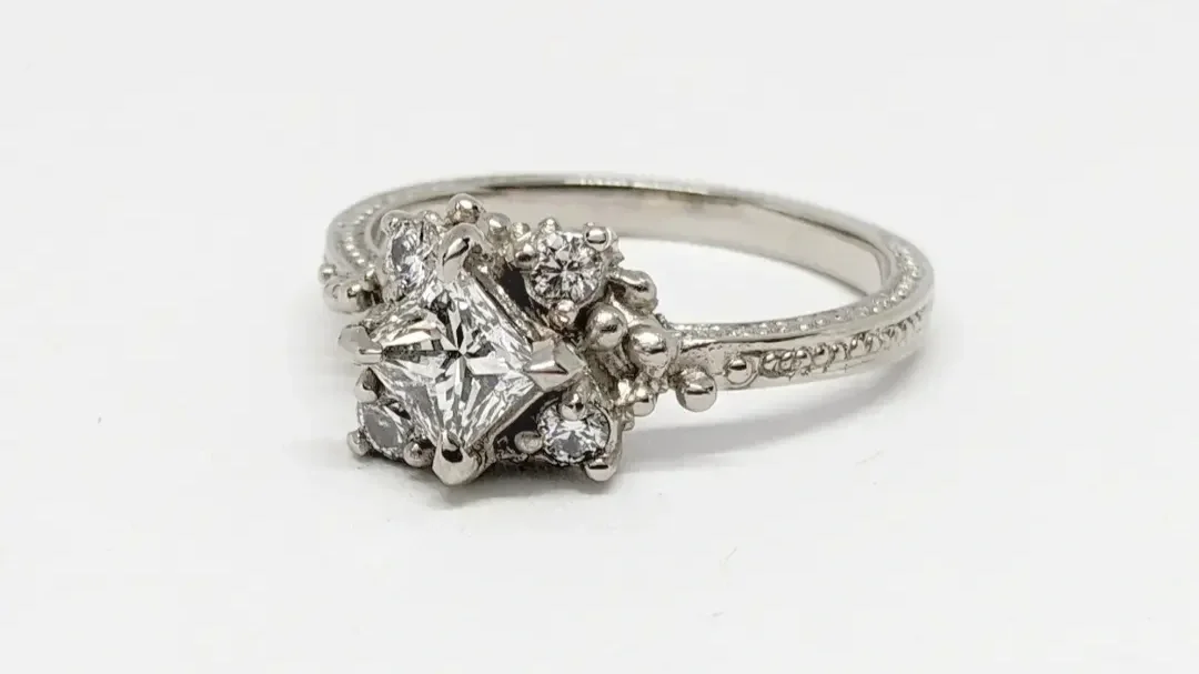 A Family Engagement Ring
This engagement ring was designed to celebrate the beautiful family the couple shares. The central stone — a princess-cut diamond — represents the fiancée, while the four surrounding diamonds symbolise their children, with th