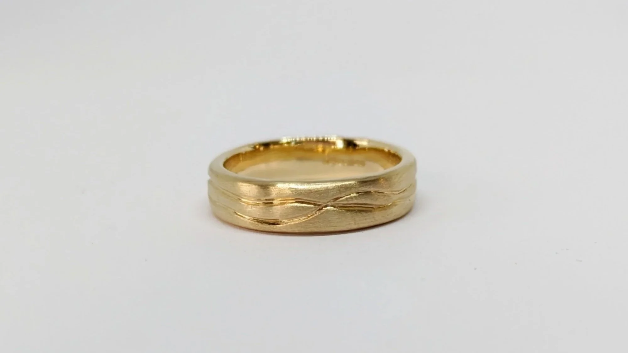 Although this simple recycled gold wedding band may not appear to match its partner in style, it is deeply connected in concept. While one ring interprets the flowing lines of the rivers through its sculptural form, this band carries the same story i
