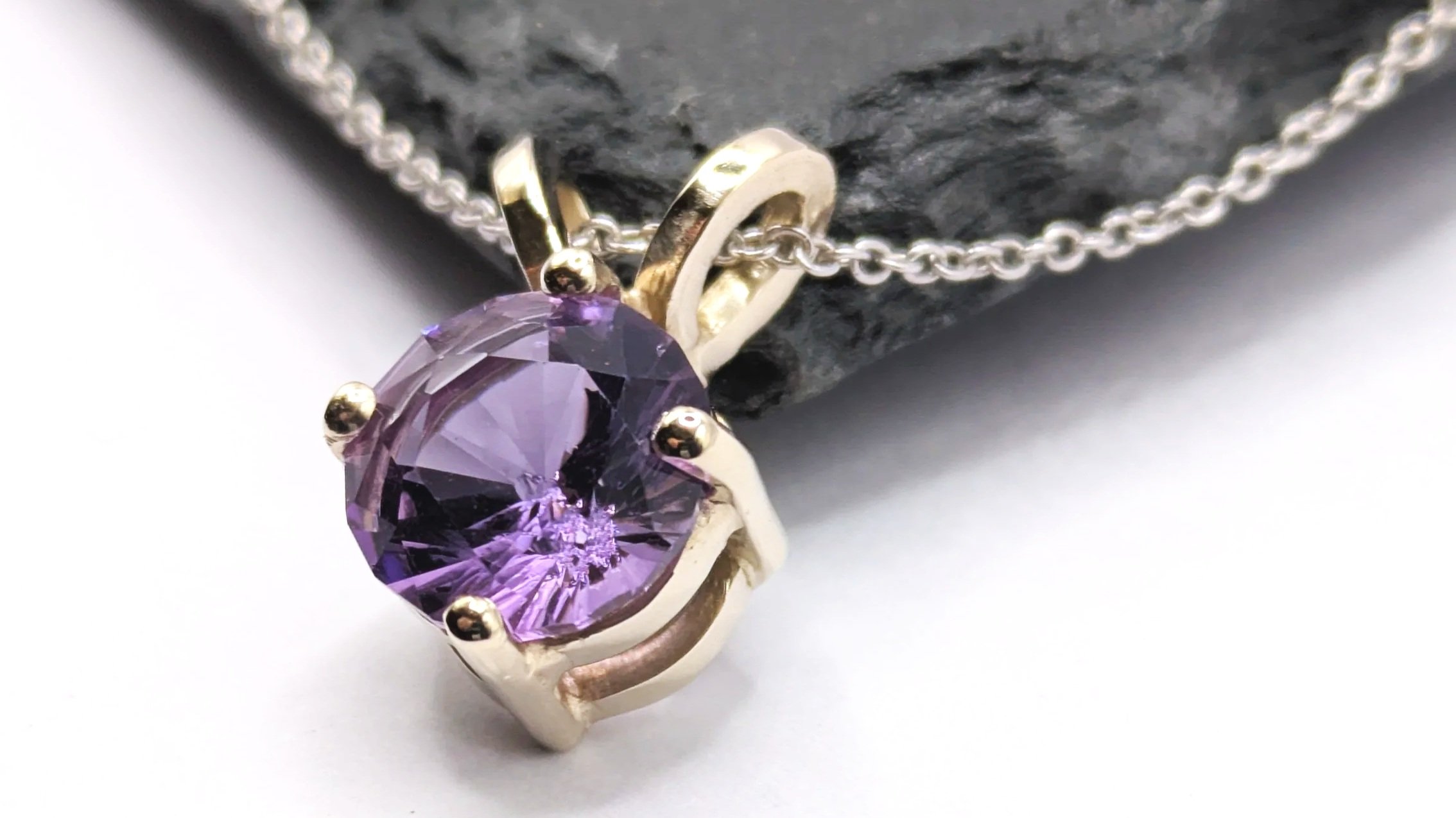 Amethyst. A simple double-gallery pendant in 18ct white gold featuring a hand-cut 10mm amethyst.