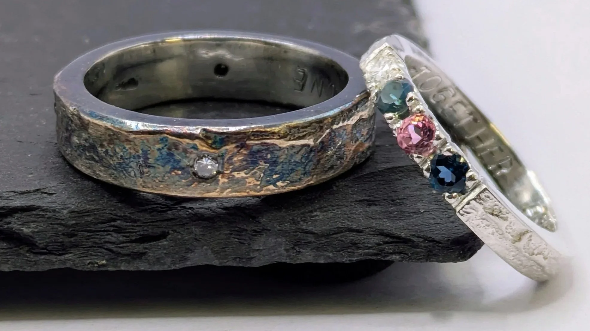 Family. A set of four sand-cast silver rings, each one set with a birthstone to represent a member of the family — mum, dad, and their two children.
Created using the same technique and sharing the same raw, organic texture, each ring is finished sli