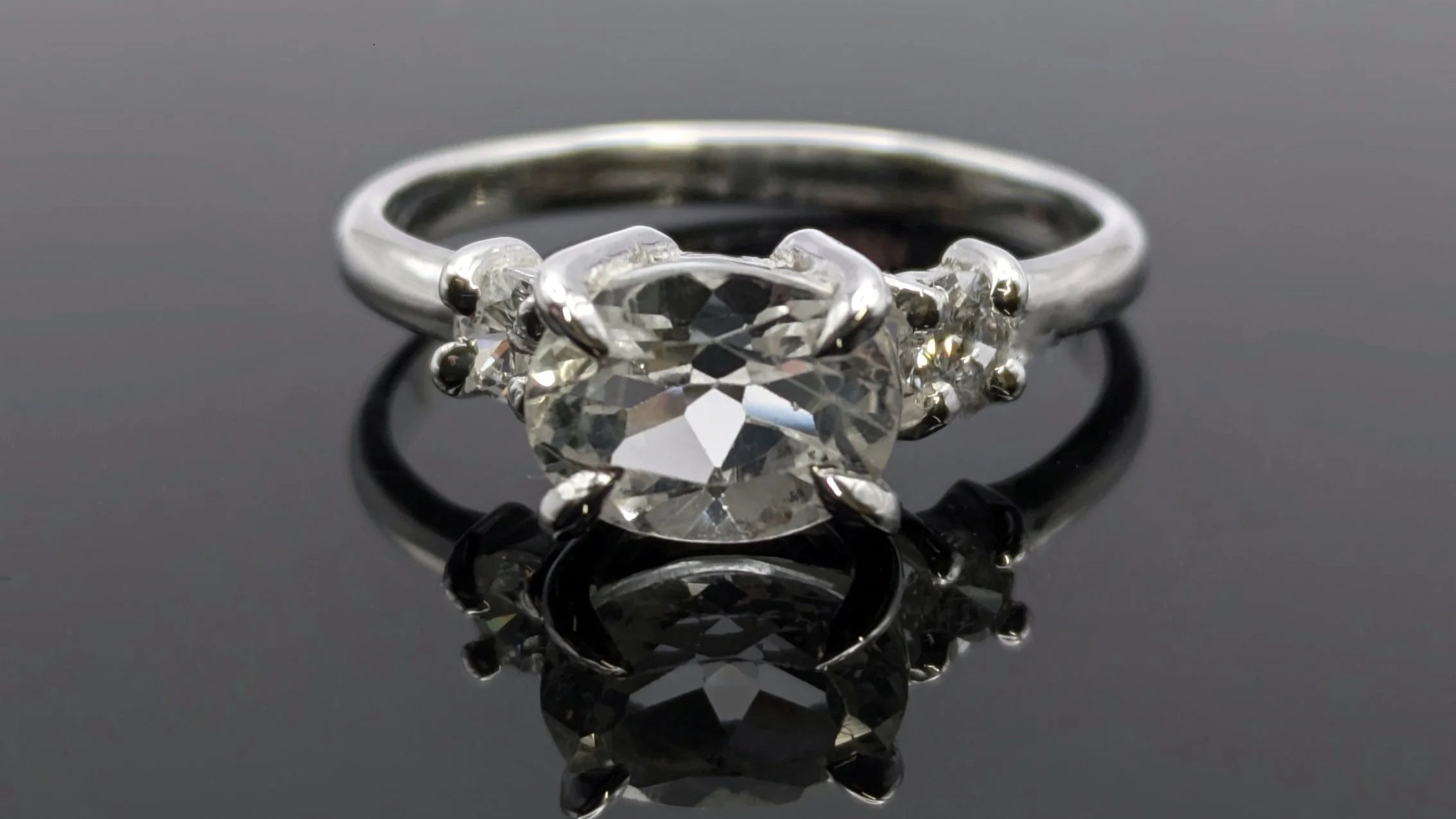 Icy Sparkle. An 18ct white gold ring with a feature oval diamond and two small accent diamonds on either side.