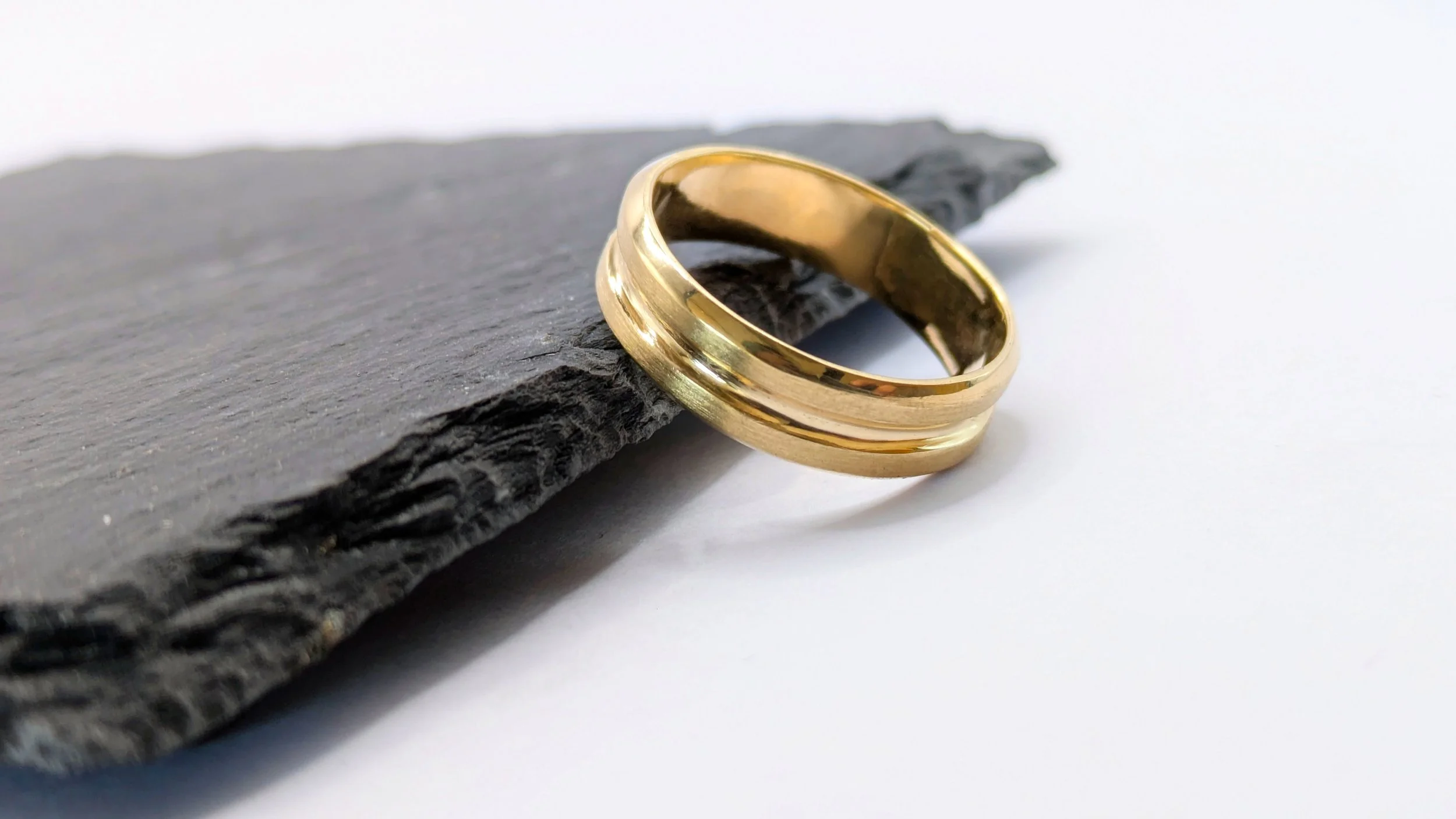 A male engagement band with a simple groove in the middle that fits the width and depth of the parters engagement ring. The perfect fit.