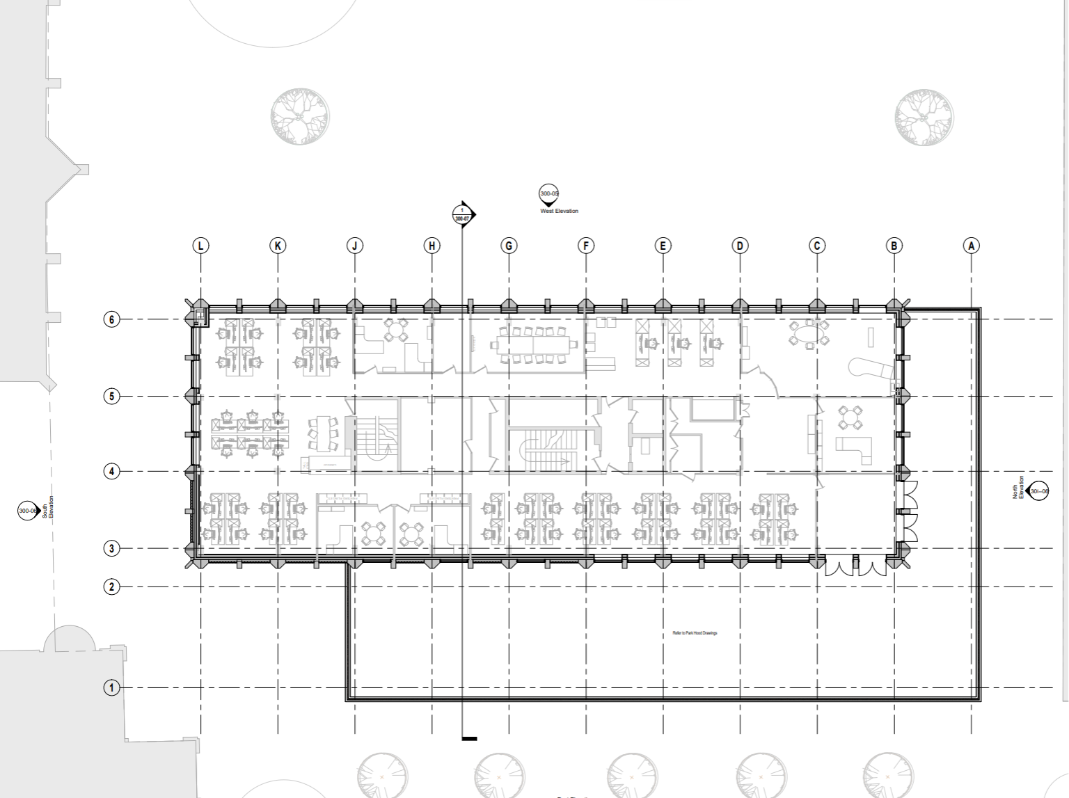 Floor plan of an office building with multiple workspaces, conference rooms, restrooms, staircases, and exterior trees.
