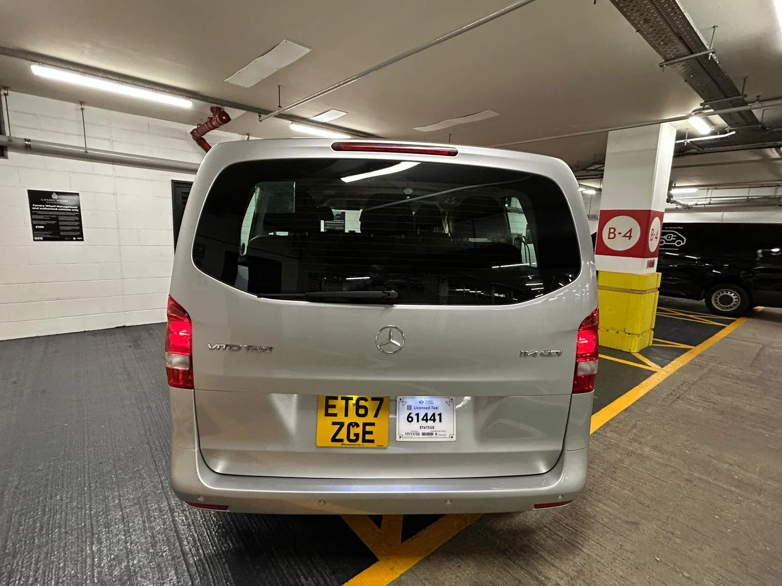 Silver Mercedes-Benz Vito van parked in an outdoor parking lot with visible yellow parking lines and surrounding signs.