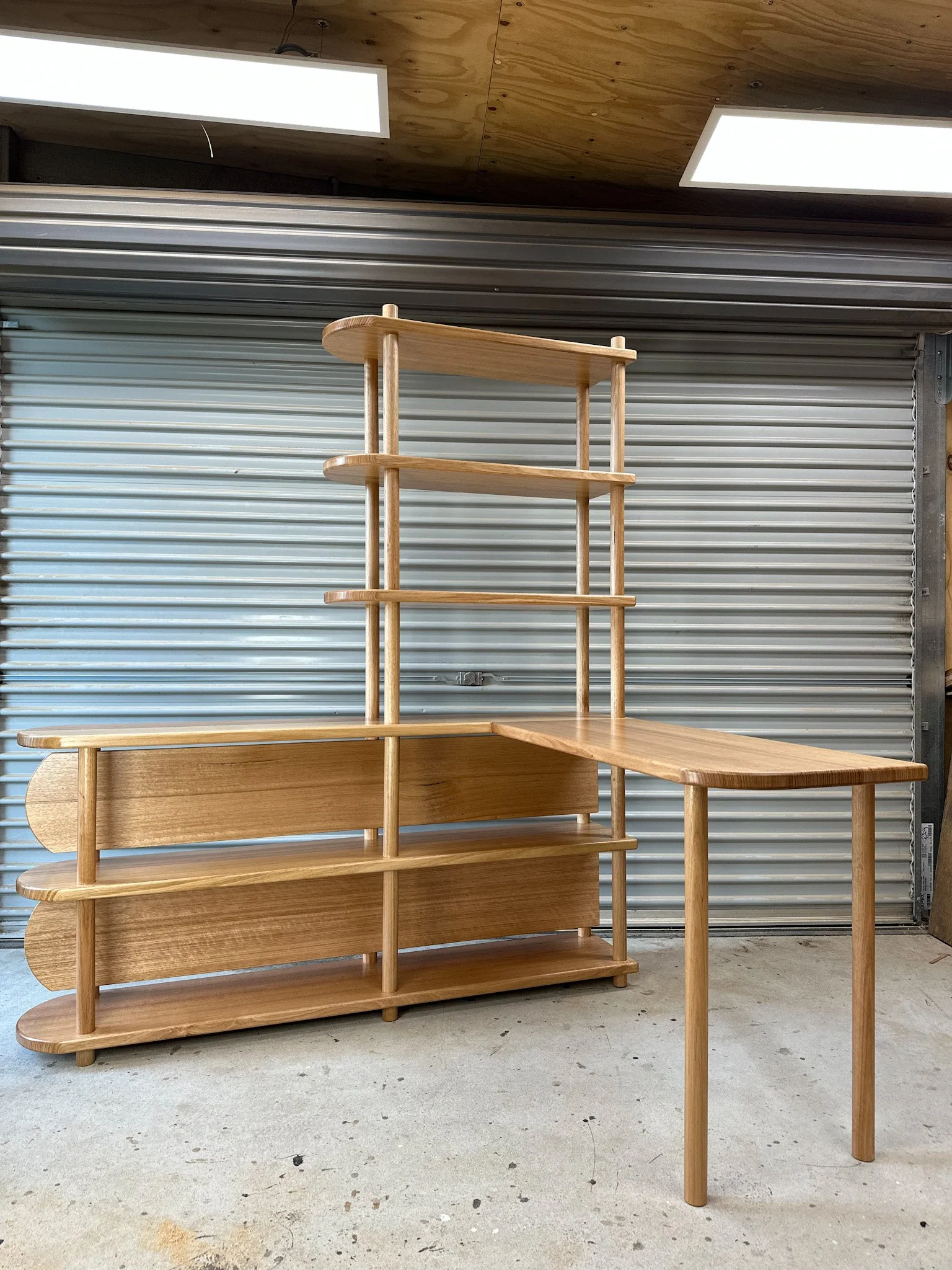 A wooden shelving unit with multiple tiers, desk, study or kitchen joinery