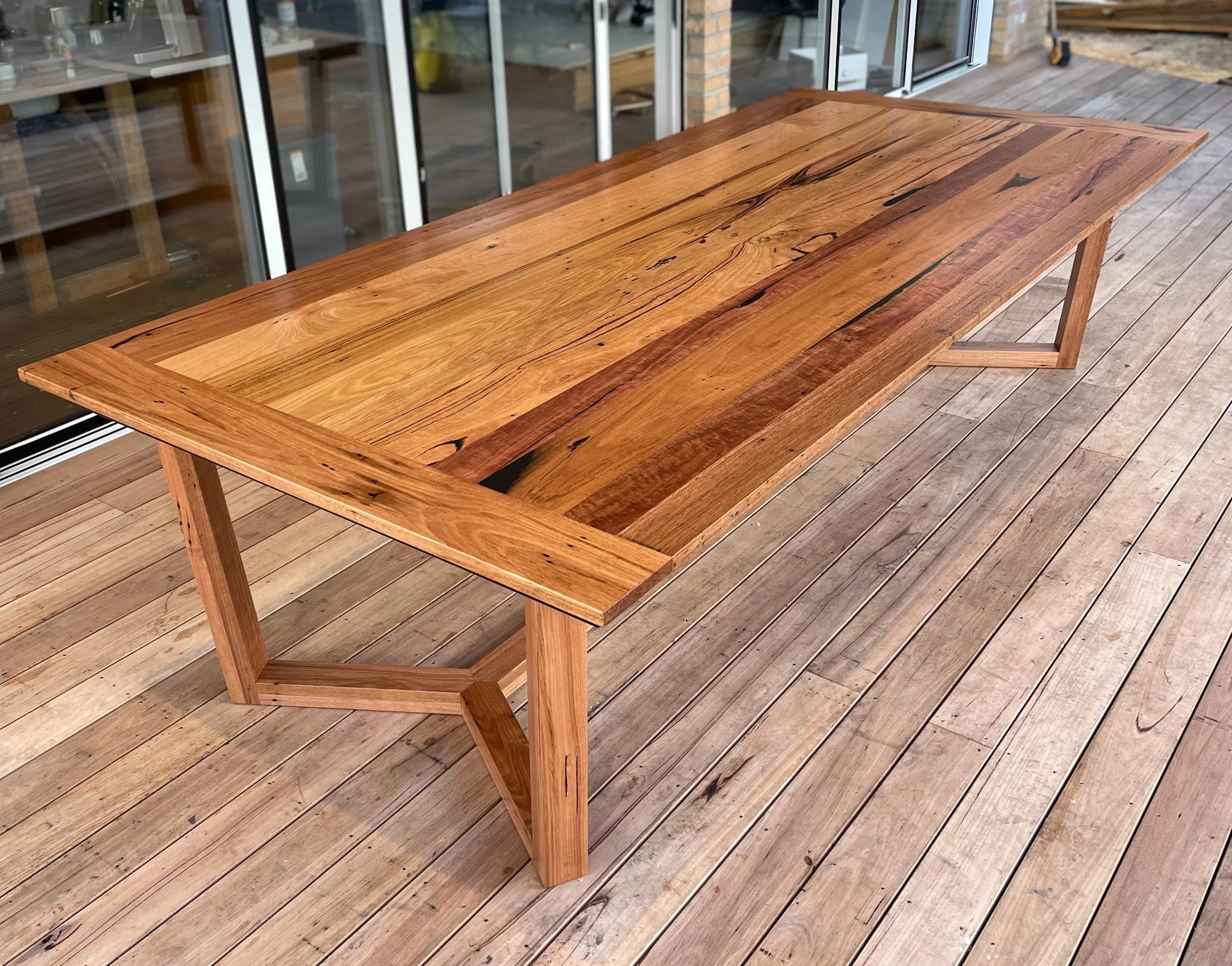 A long rectangular wooden dining table with a natural wood finish 
