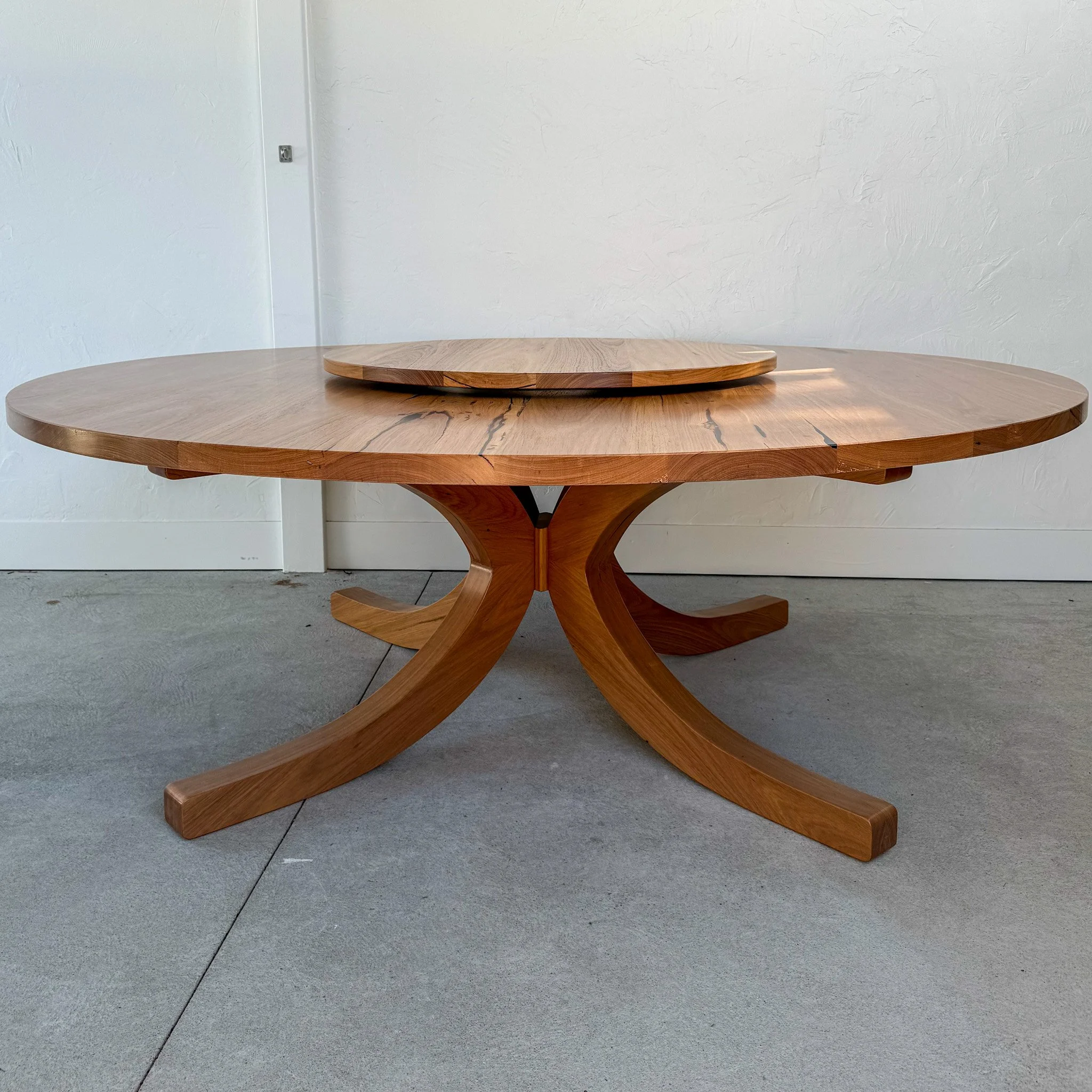 Bespoke round timber dining table with lazy susan and sculpted base, handcrafted by Daniel Charles Studio Melbourne