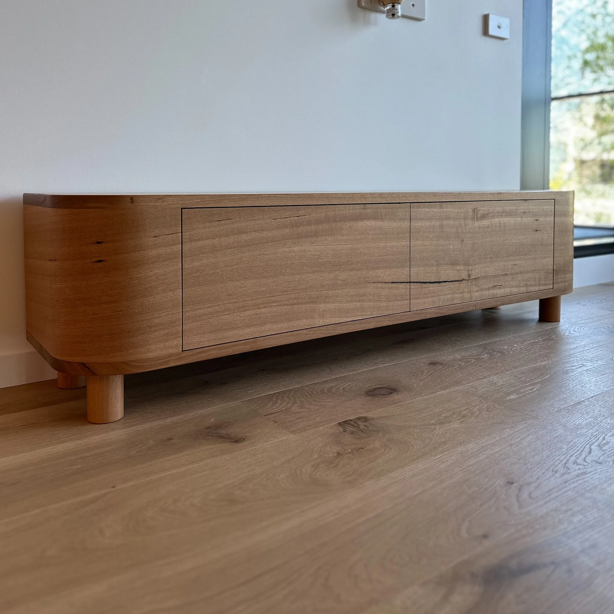The image shows a wooden sideboard or entertainment unit 