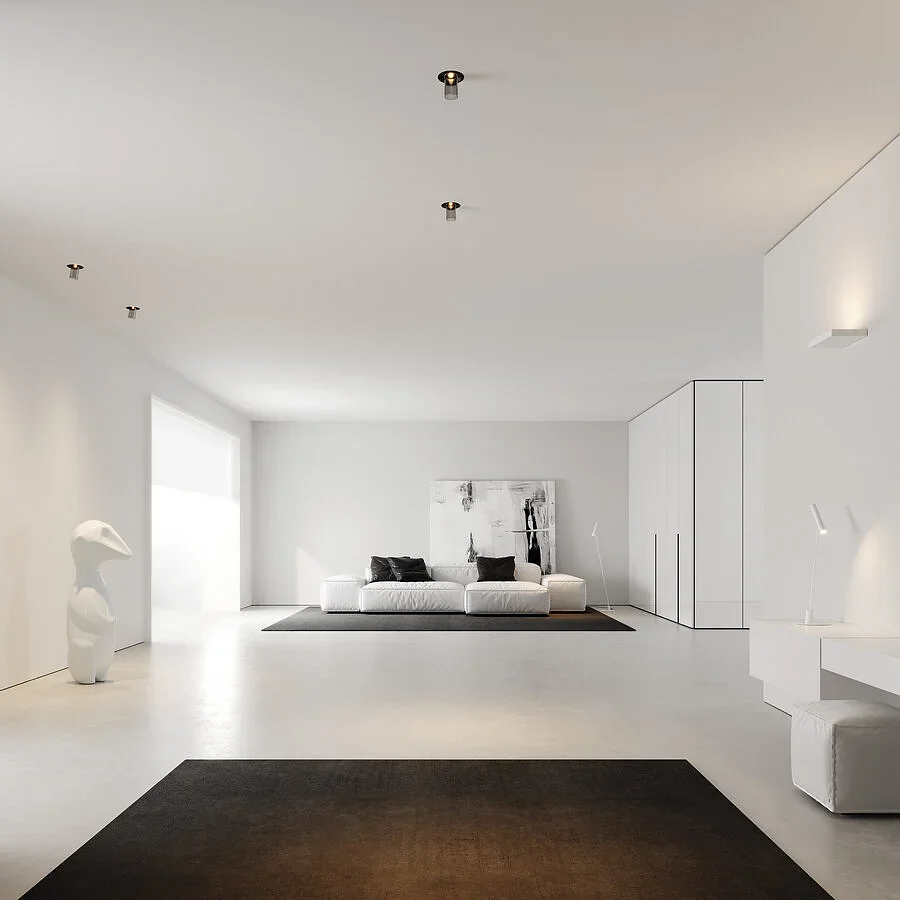 Interno minimalista con pareti e pavimenti bianchi, divano bianco con cuscini scuri, decorazioni moderne, sculture e lampade sleek.