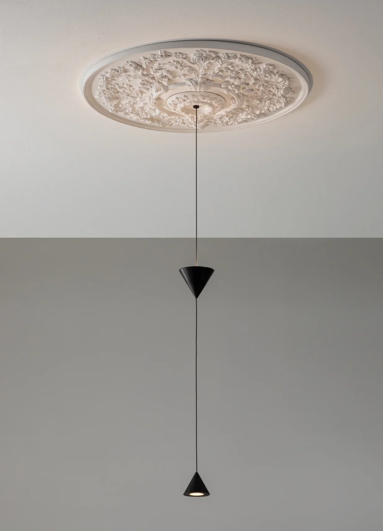 Luce pendente nera con forma conica, sospesa da un soffitto decorato con soffitto ornato in stile classico.