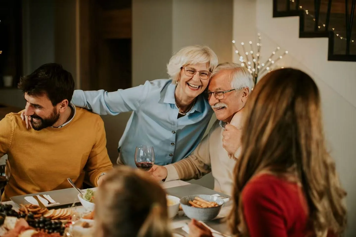 Family gathered around a dinner table, laughing and enjoying a meal together.