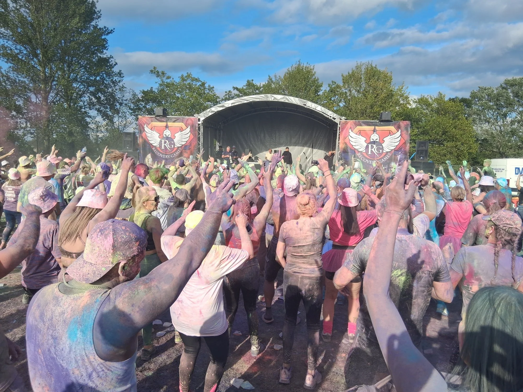 The crowd celebrating at the colour party in front of the Recovery Games main stage