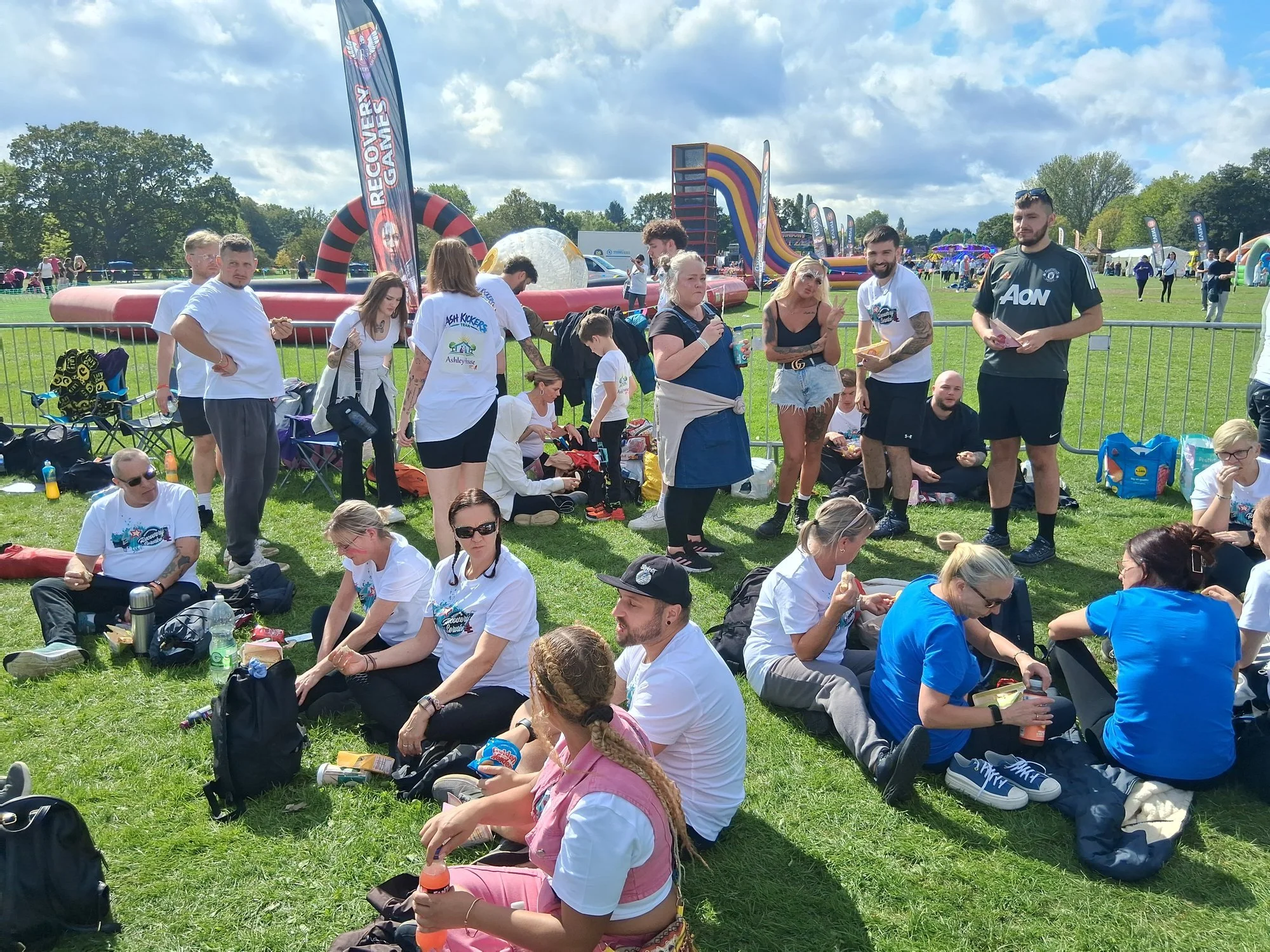 Team members taking a break on the grass between challenges at Sandall Park