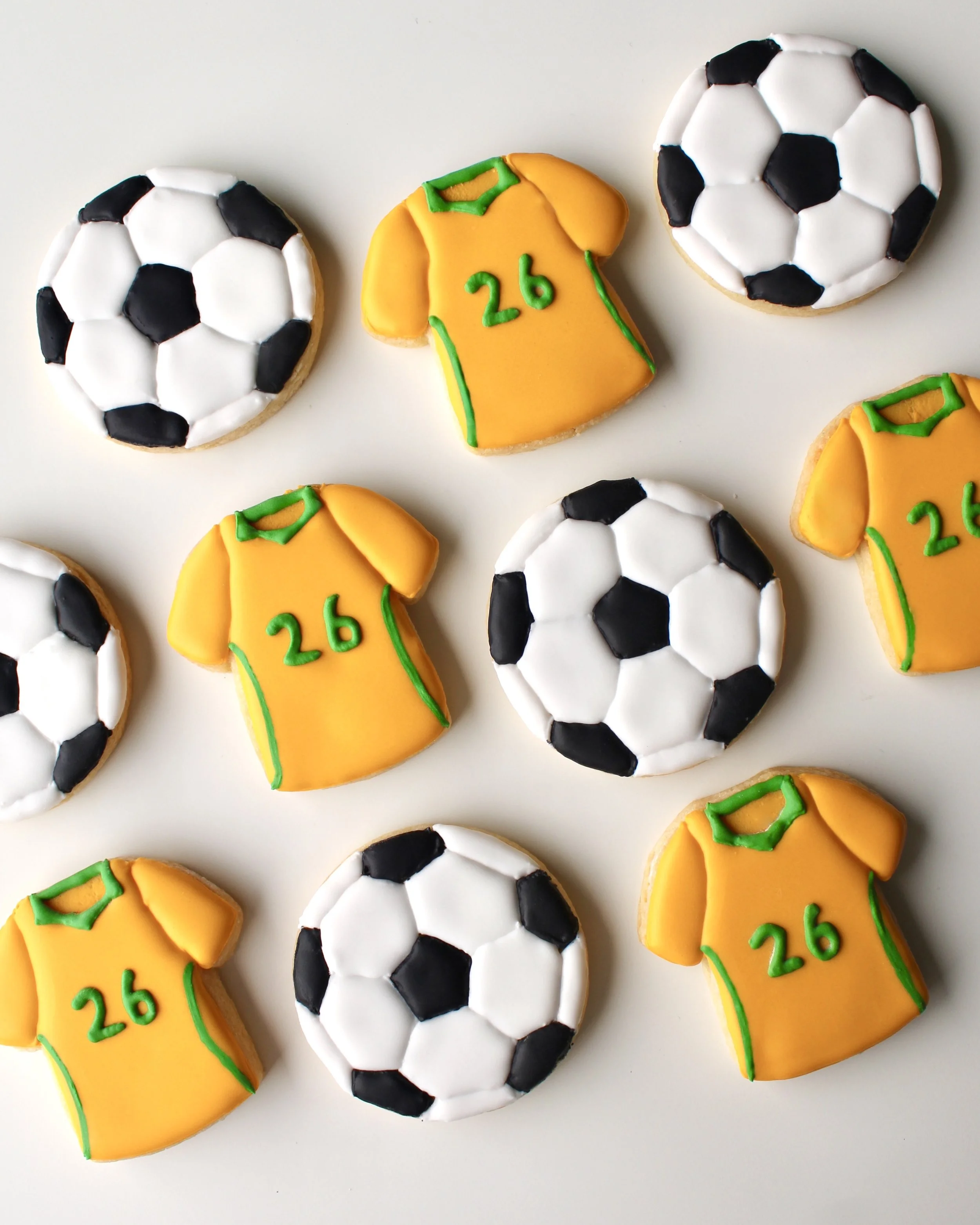 Soccer theme cookies with two designs: Socceroos style jersey cookie with green accents and 26 detail, and soccer ball cookie