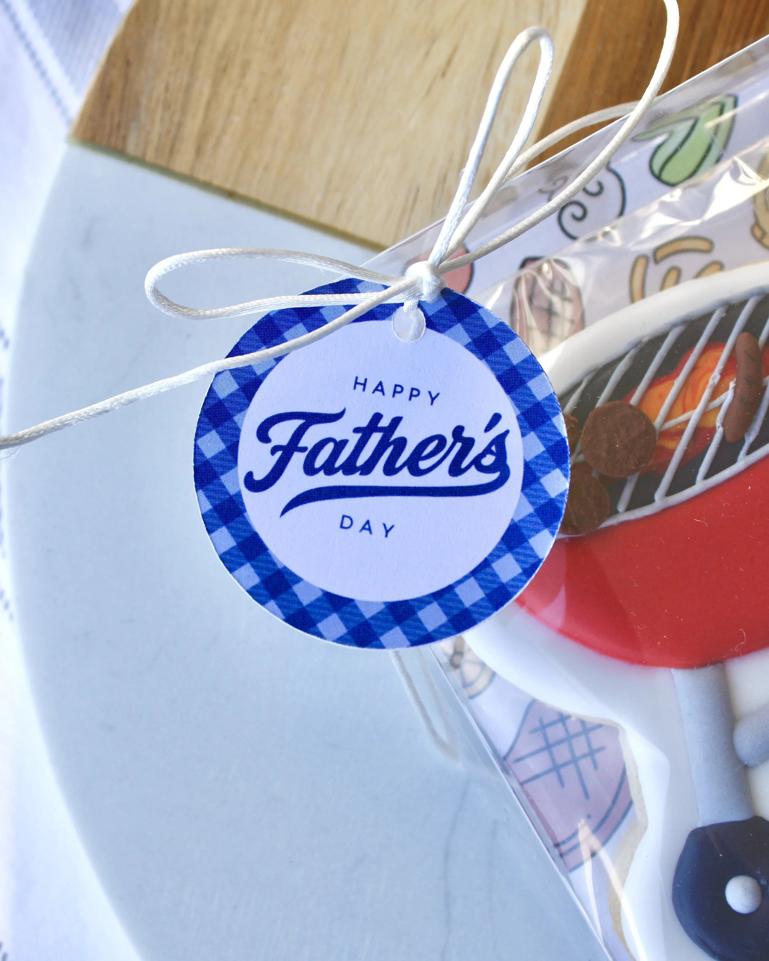 Close up of a round blue and white gift tag with "Happy Father's Day" written on it.