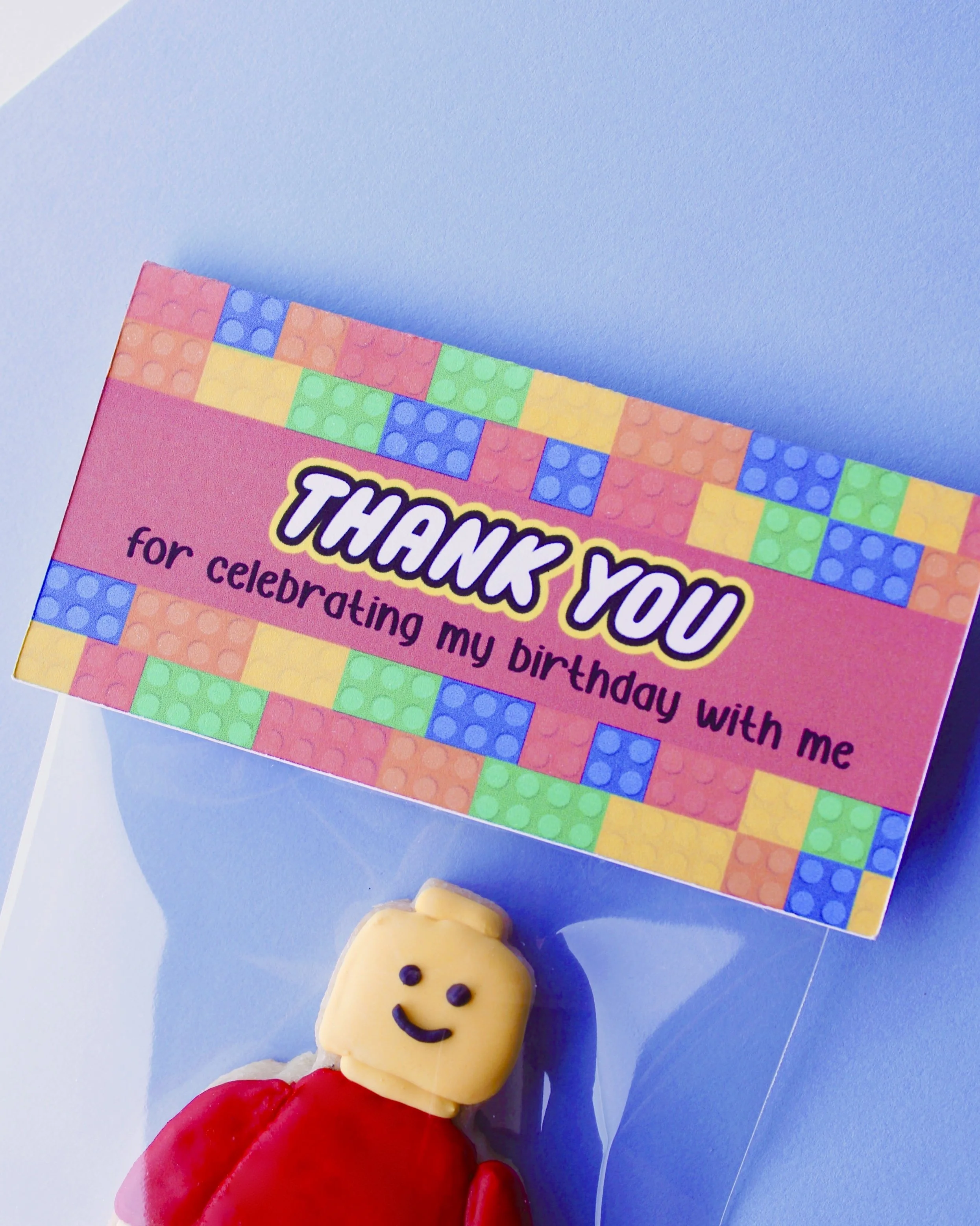 Close-up of a cookie bag with a “Thank You for Celebrating With Me” topper and colourful building blocks in the background.