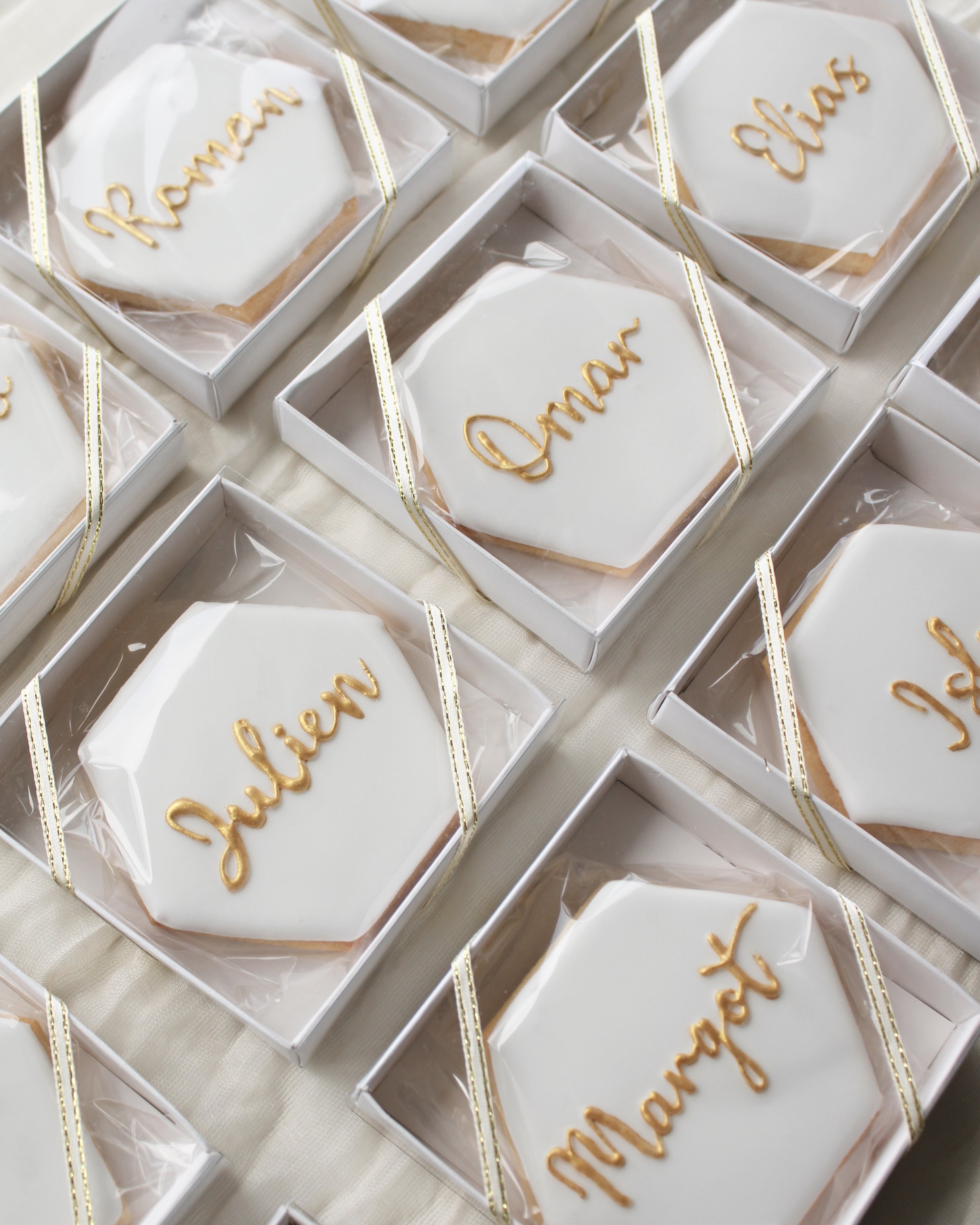 Wedding place card cookies with gold script guest names