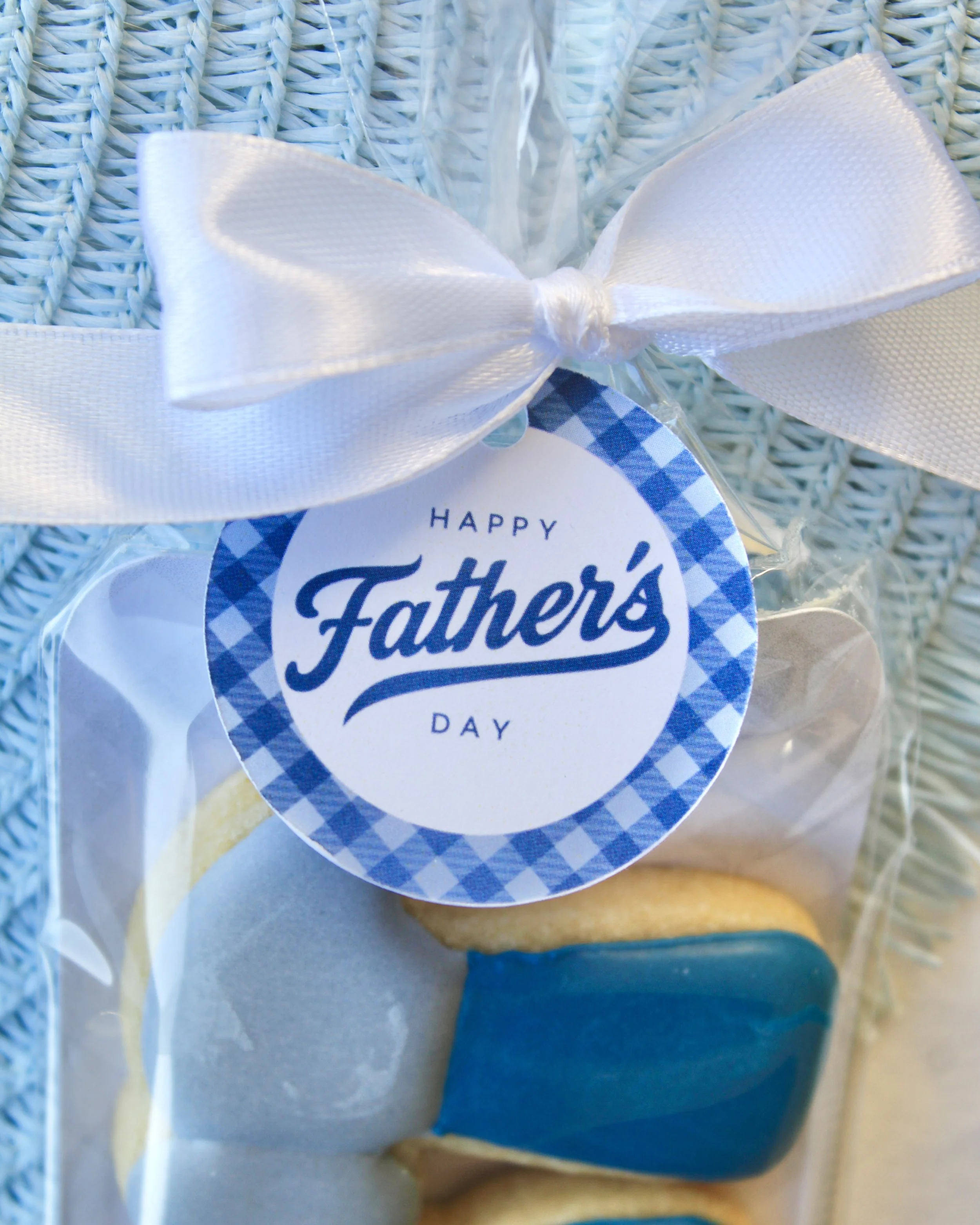 Close up of Happy Fathers Day gift tag, tied with white ribbon bow.