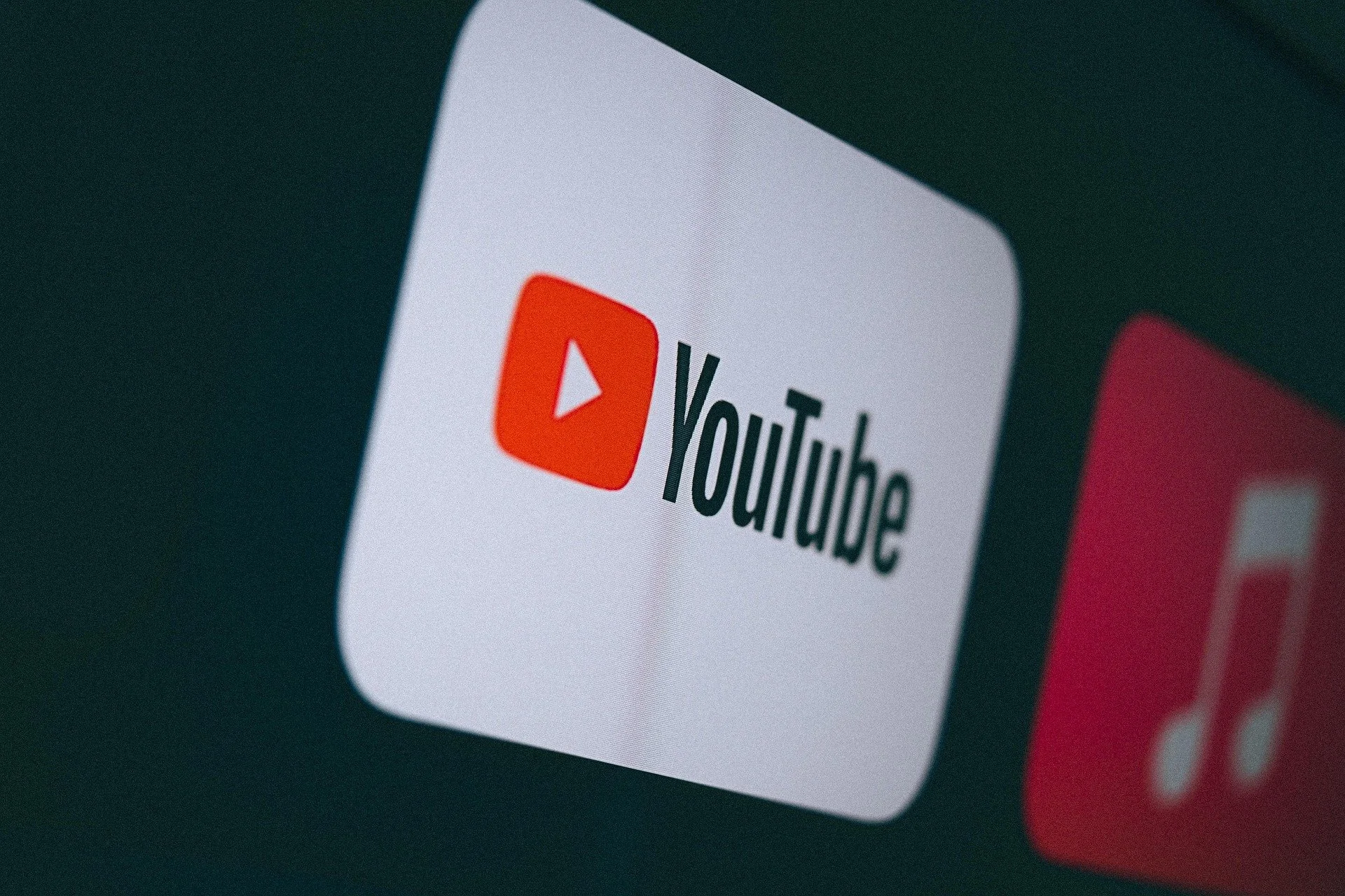Close-up of a smartphone screen displaying the YouTube app icon on a dark background.