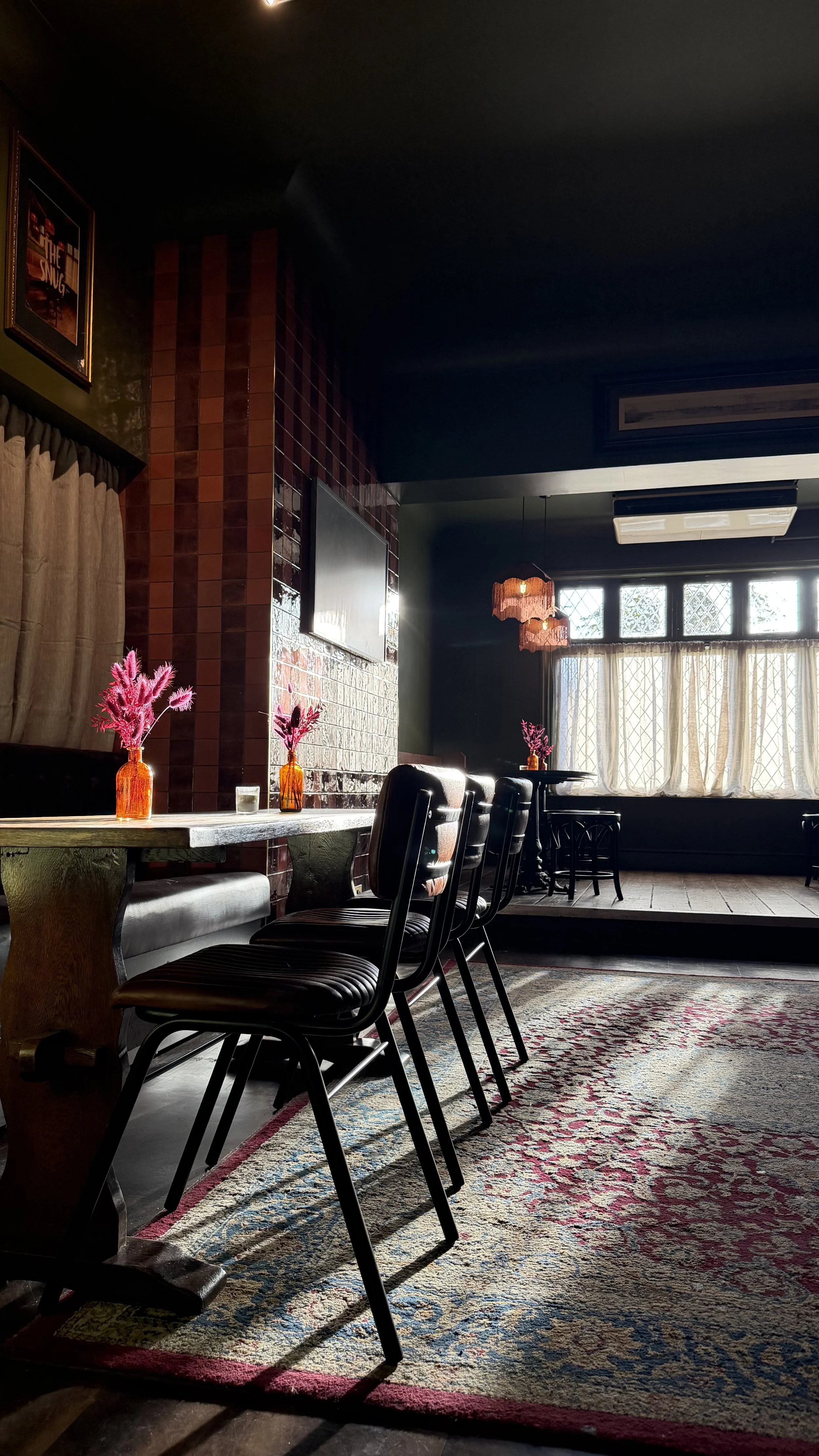 The Snug, a cosy private room with bar seating and flowers at the Admiral Cunningham, Bracknell