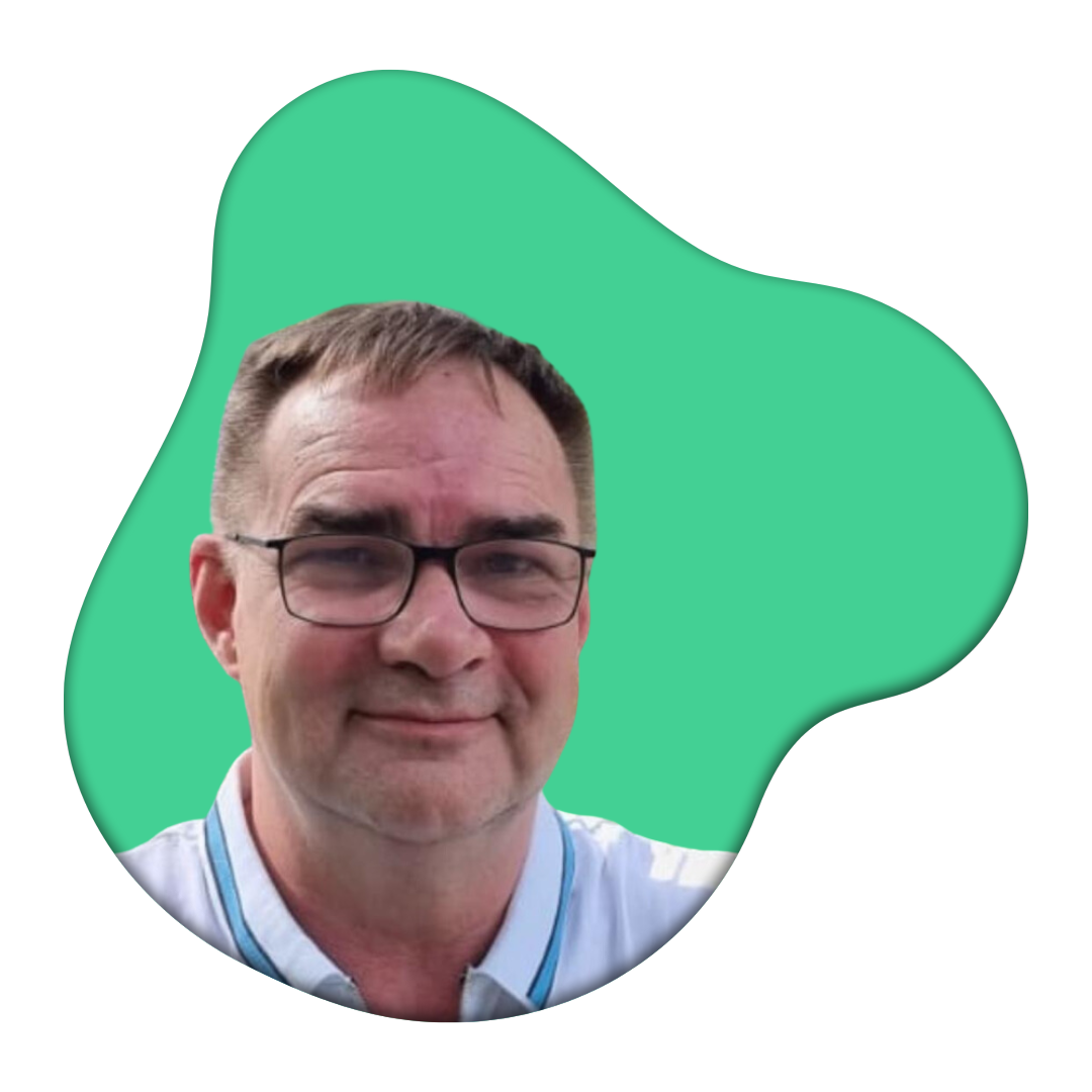 Porträt eines Mannes mit Brille und weißen Hemd vor grünem Hintergrund.