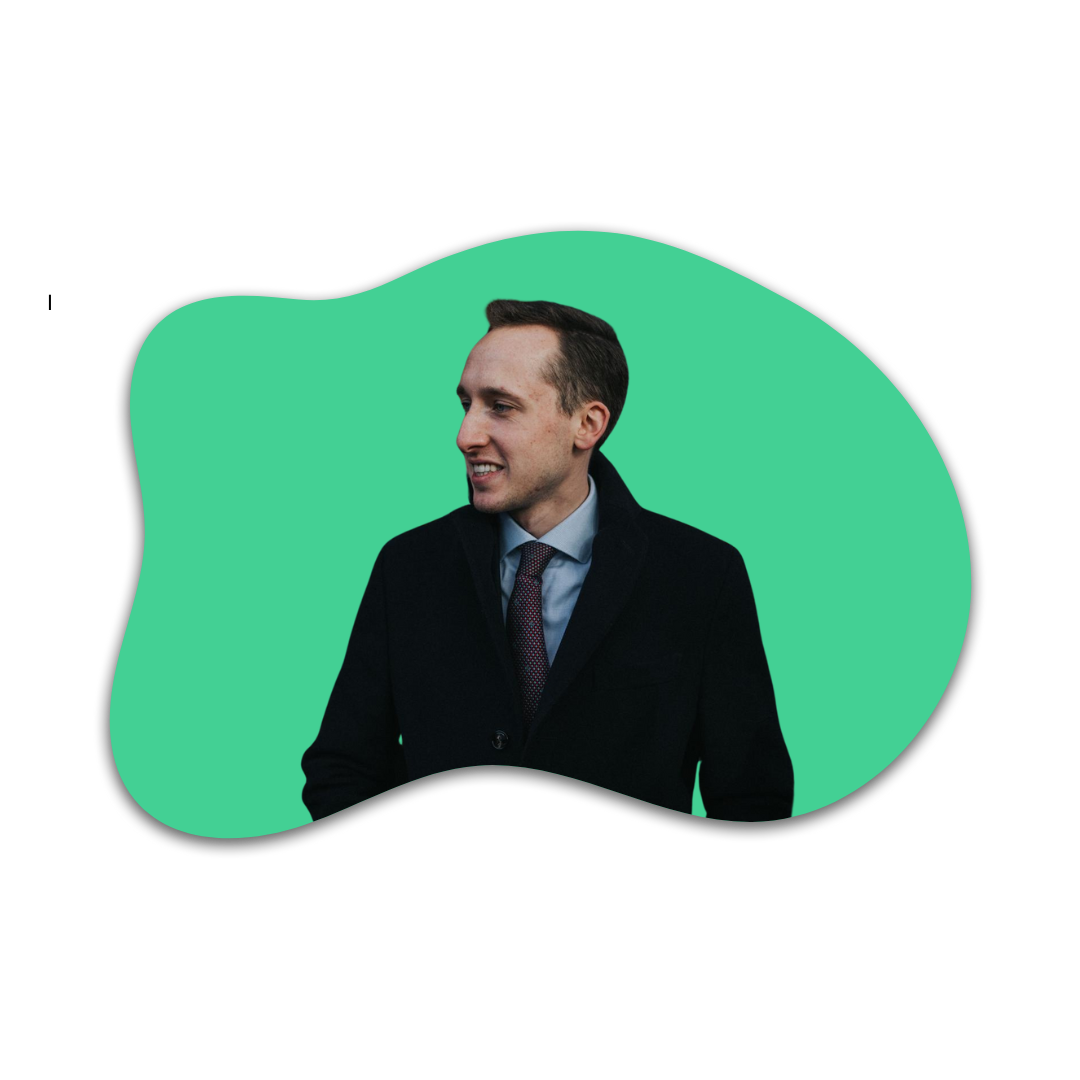 Junge Mann in Anzug lächelt, dunkle Haare, im Hintergrund grüne Form