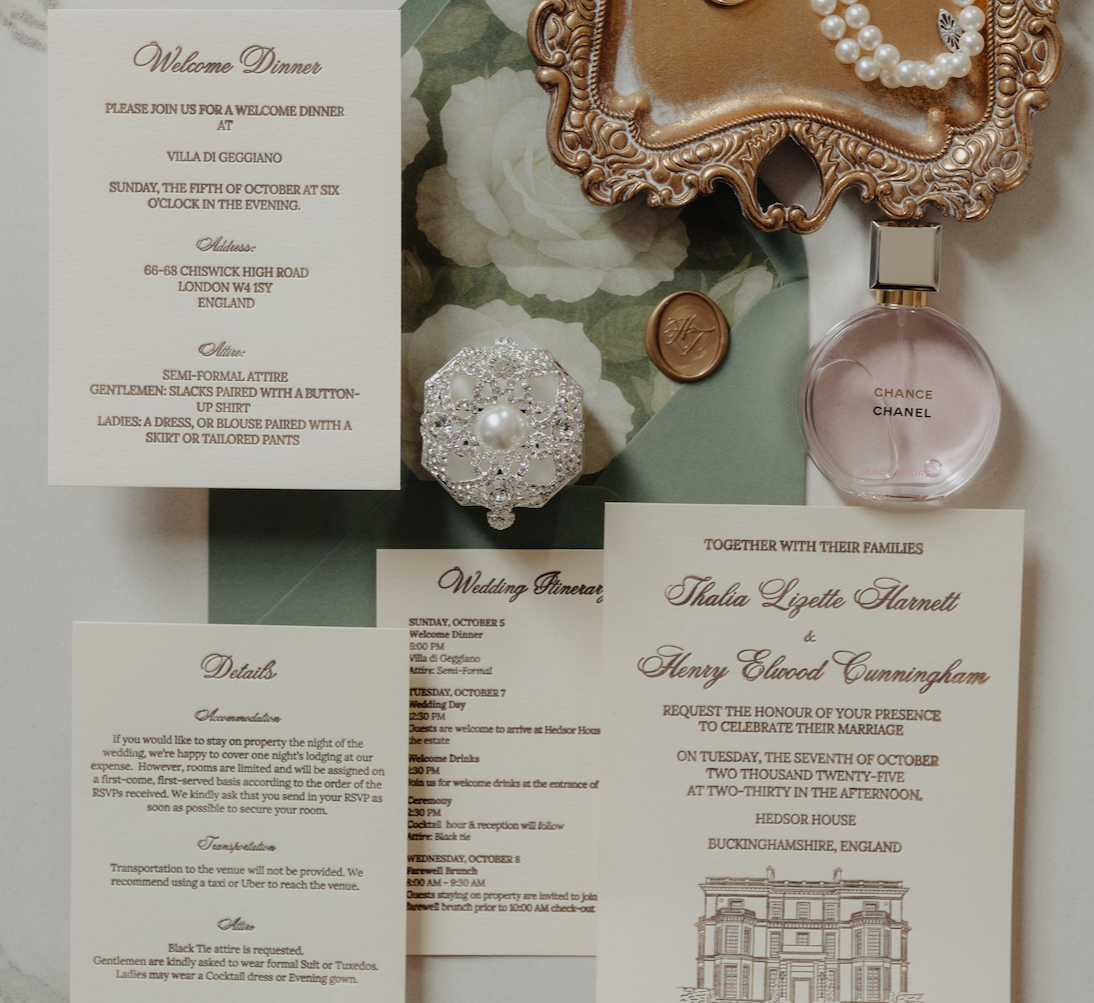 Wedding invitation suite with a welcome dinner card, a detailed itinerary, and a wedding card. The suite also includes jewelry, a perfume bottle labeled 'Chance Chanel', a pearl necklace, a gold bracelet, and a decorative mirror or jewelry box.