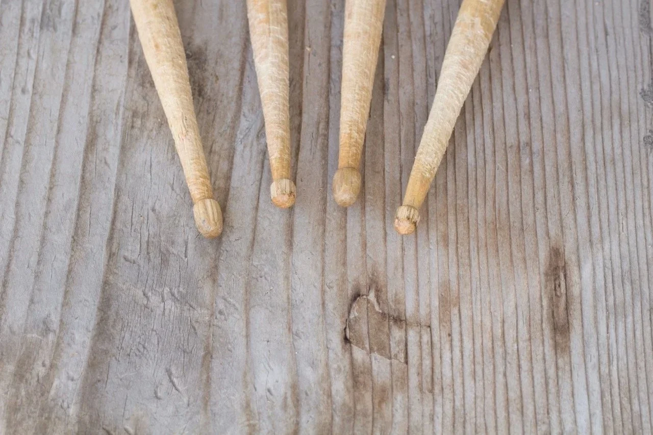 Quattro bacchette di legno su una superficie di legno.