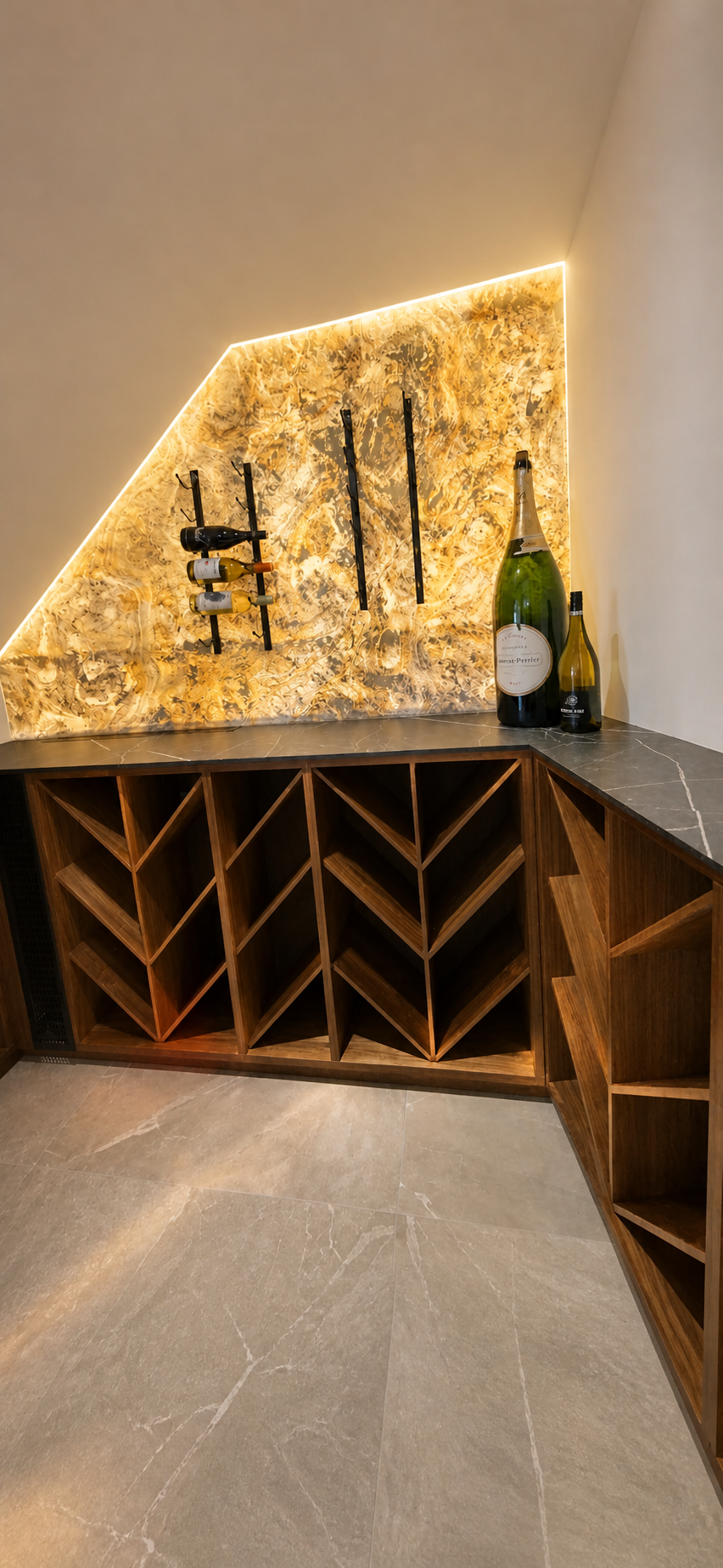 Modern wine storage area with a wooden wine rack, a stone countertop, and a decorative backlit wall with a marbled pattern. Several wine bottles are displayed on the countertop.