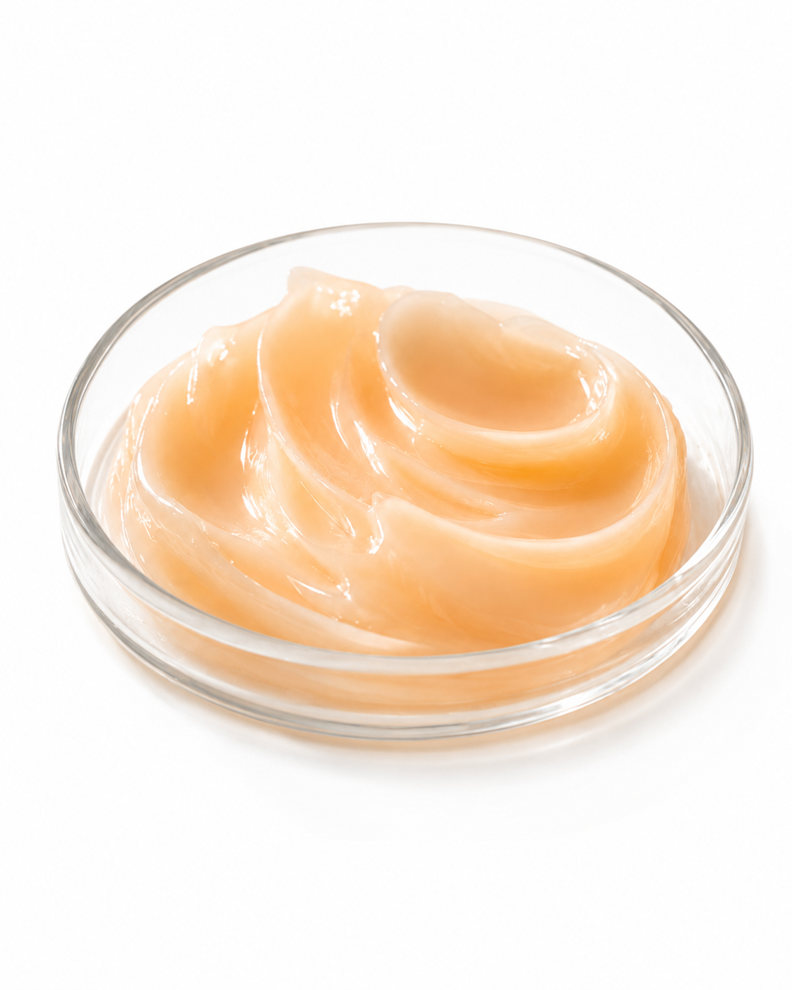 Close-up of pale orange milky vitamin C cream swirled in a clear glass dish on a clean white background.