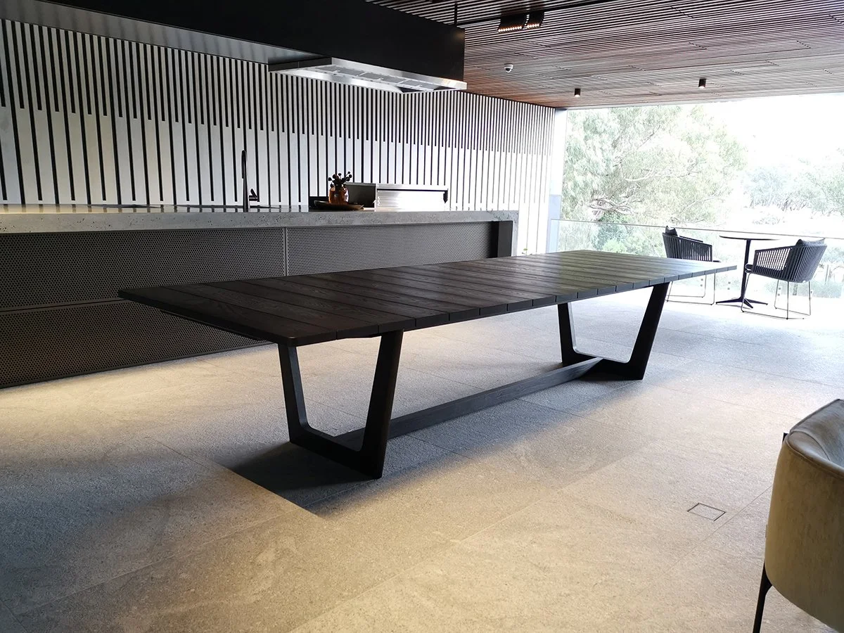 Eden Outdoor Table in ebonised timber - Nathan Day Design, angled view showing angular V-leg design in modern lounge setting
