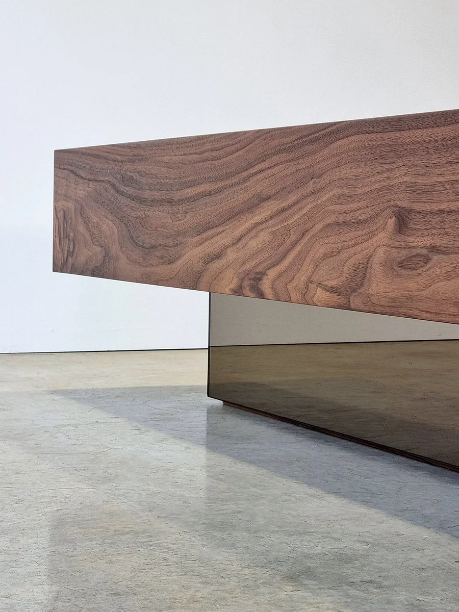 Detail of the Parker St Coffee Table's mitred American Walnut top floating over its bronze mirror base - Nathan Day Design
