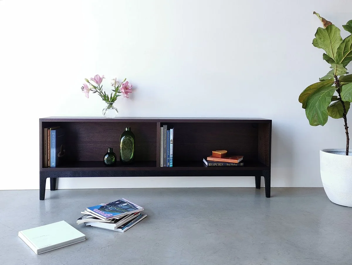 Sally's Bookcase in ebonised and scorched Jarrah, full front view styled with magazines on floor - Nathan Day Design