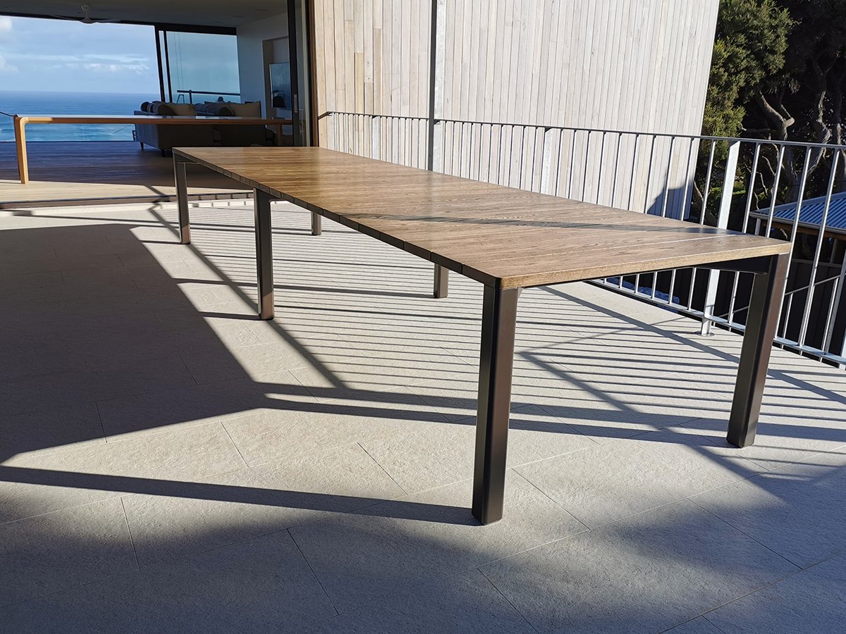 Wardanup Outdoor Table in American Oak - Nathan Day Design, ocean-view balcony lifestyle shot with black steel legs
