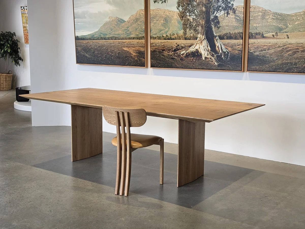 Tulip Chair in American Oak beside matching Oak dining table, showroom setting with framed outback landscape triptych artwork behind - bespoke commission by Nathan Day Design