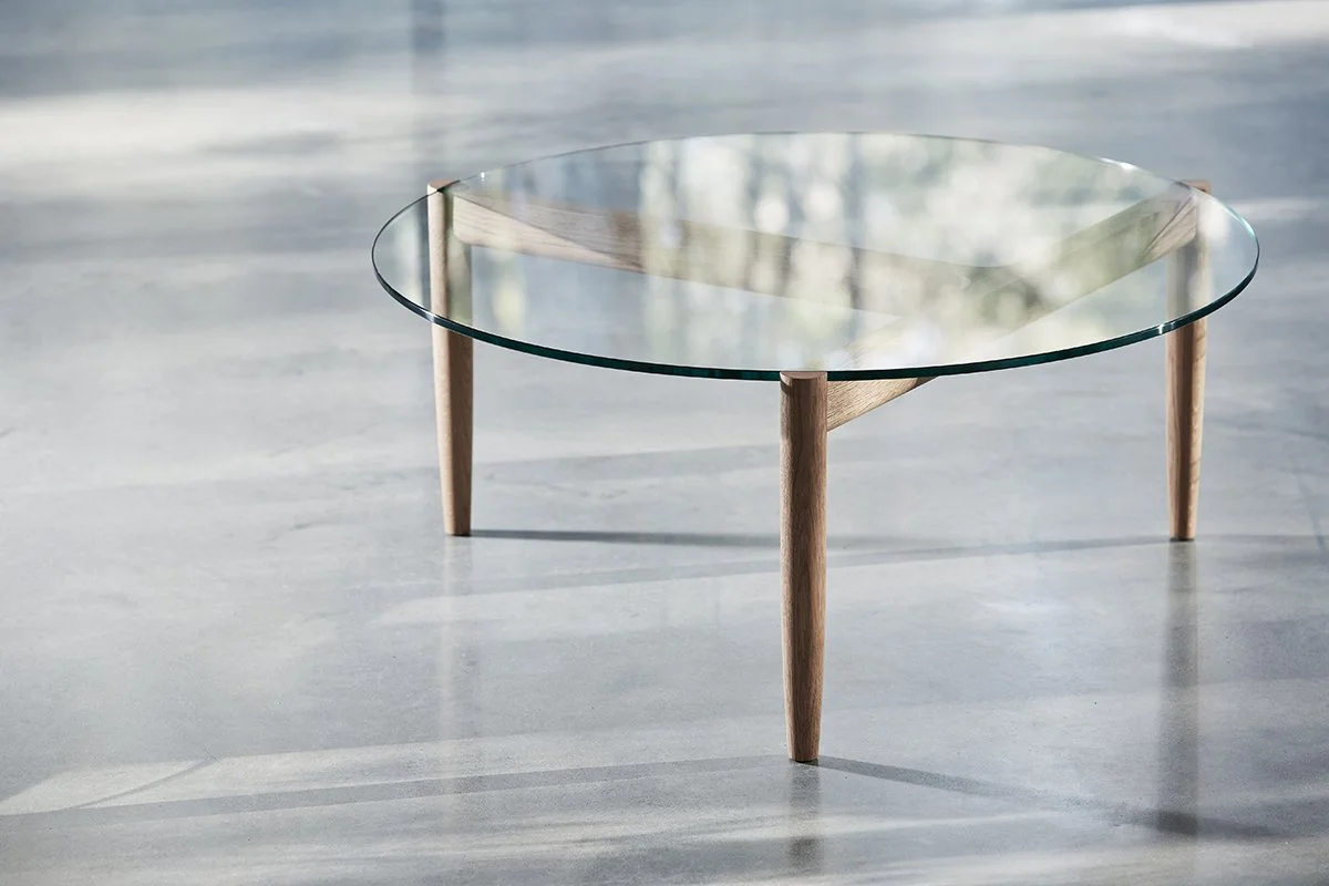 3.2.1 Coffee Table in American Oak with clear glass top, reflecting greenery through a nearby window - Nathan Day Design