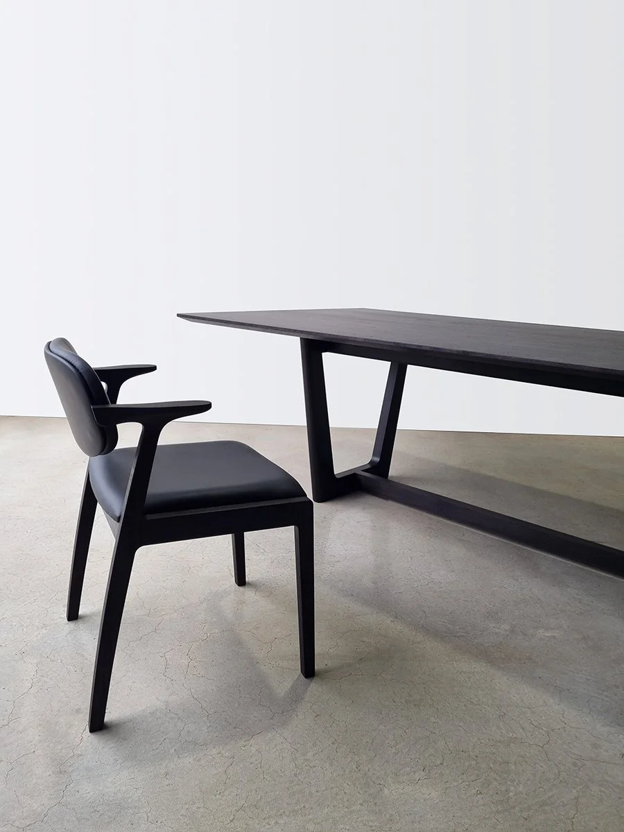 Kinross Chair in ebonised black timber with black leather upholstery beside a matching ebonised table - bespoke furniture by Nathan Day Design