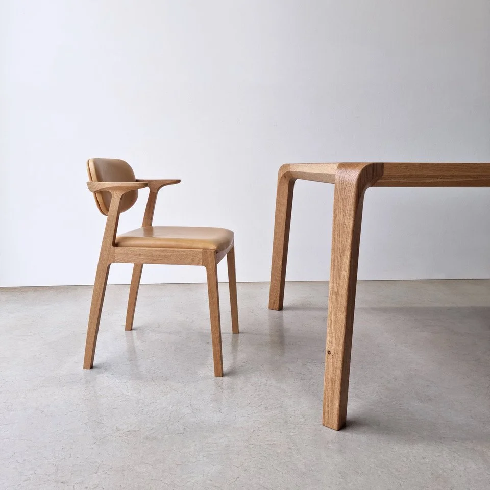 Kinross Chair in American Oak paired with a matching Irvine Table leg, plain studio setting - bespoke furniture by Nathan Day Design
