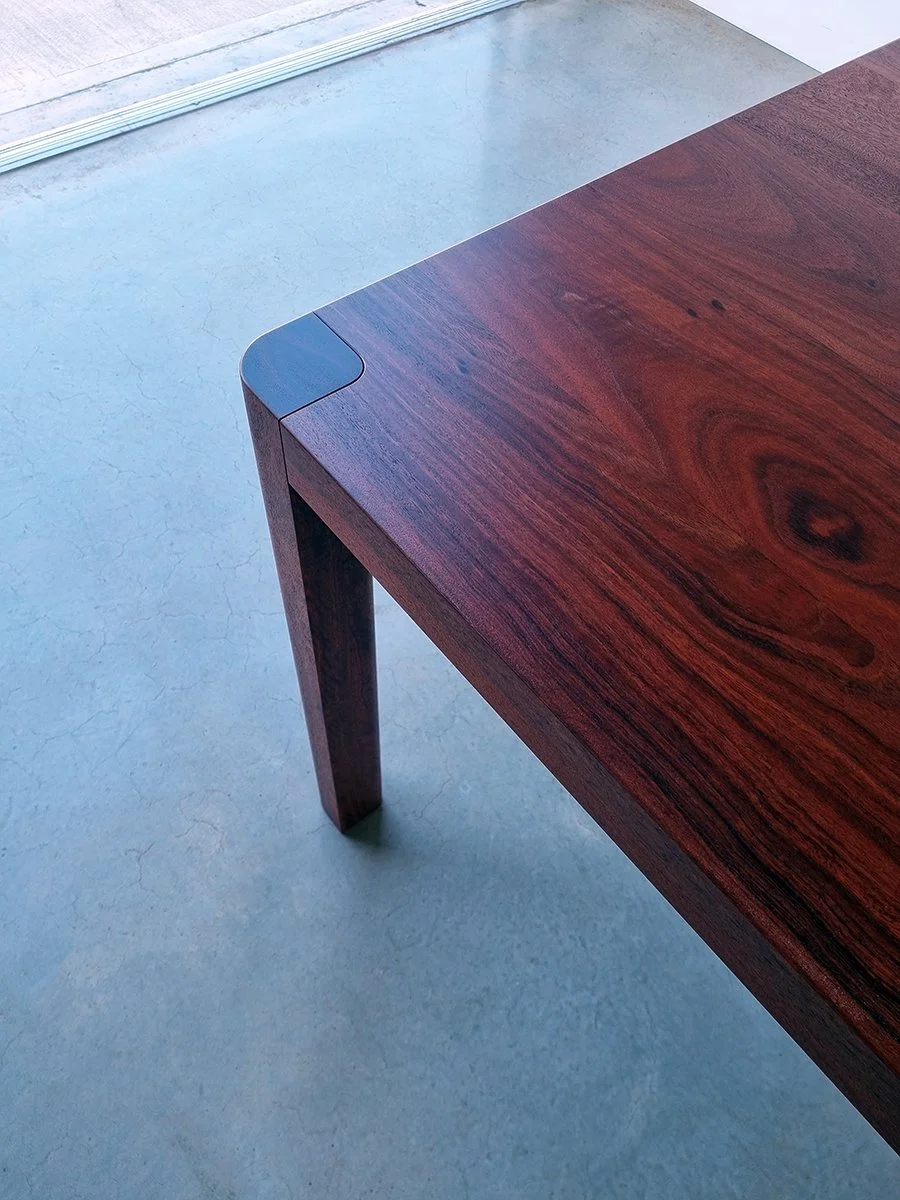 Close-up detail of Irvine Table in Jarrah showing rich red timber grain and tapered leg corner - bespoke furniture by Nathan Day Design
