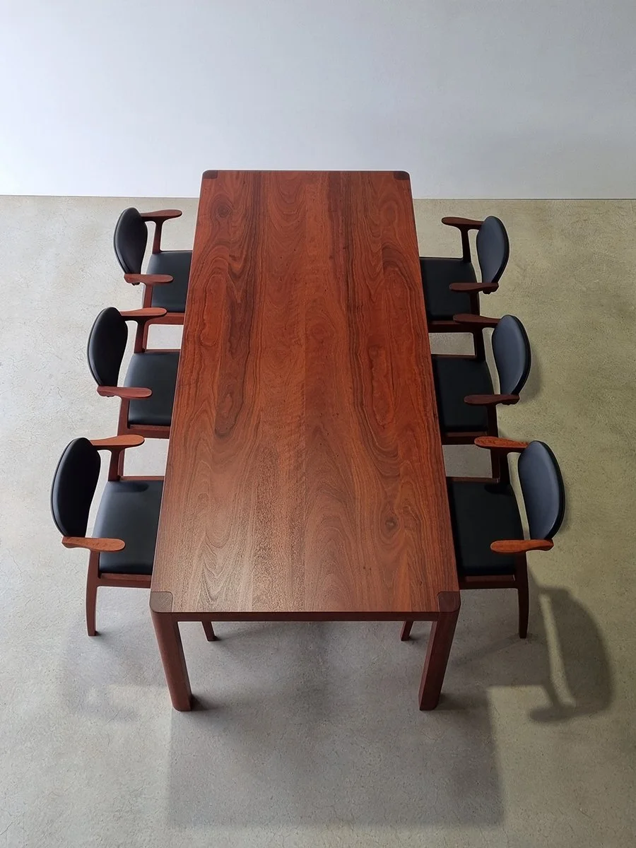 Overhead view of six Kinross Chairs in Jarrah with black leather upholstery set around an Irvine Table - bespoke furniture by Nathan Day Design