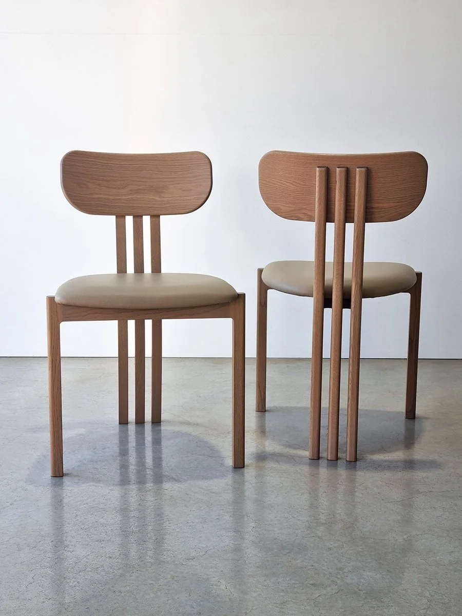 Pair of Tulip Chairs in American Oak with tan leather seats, front and side-back views shown together in showroom setting - Nathan Day Design bespoke furniture