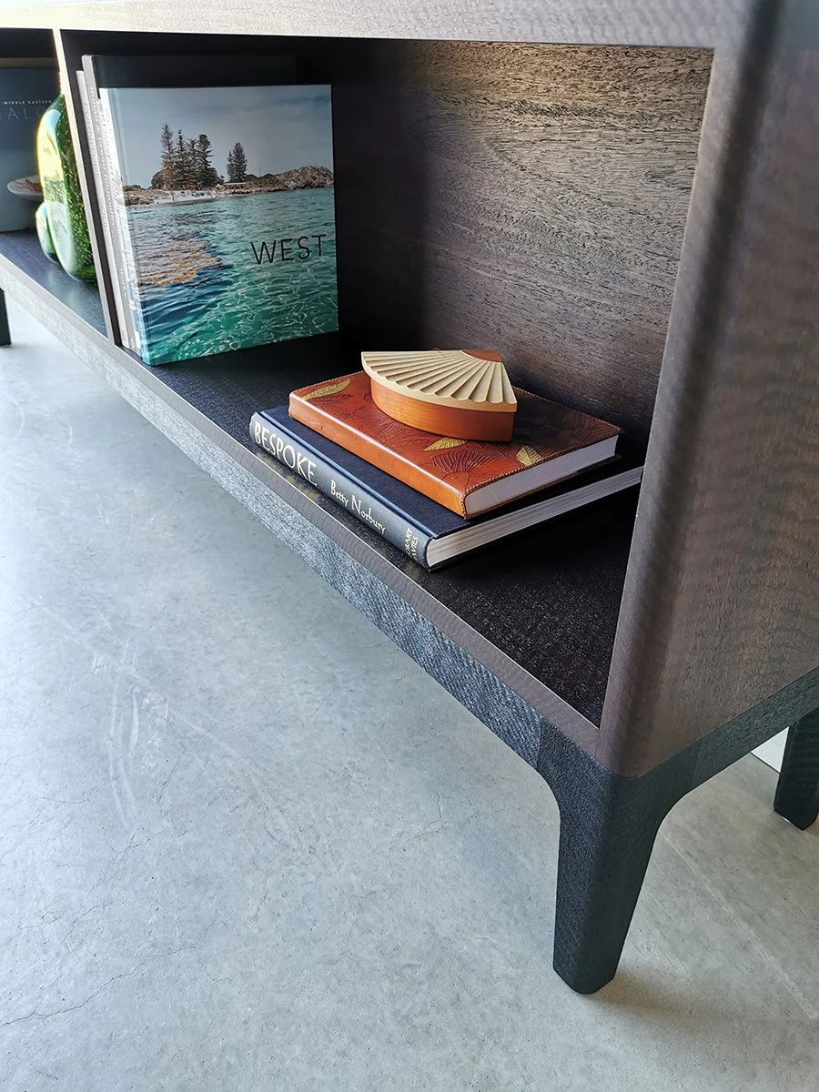 Sally's Bookcase in ebonised and scorched Jarrah, close-up shelf detail styled with a framed art book - Nathan Day Design