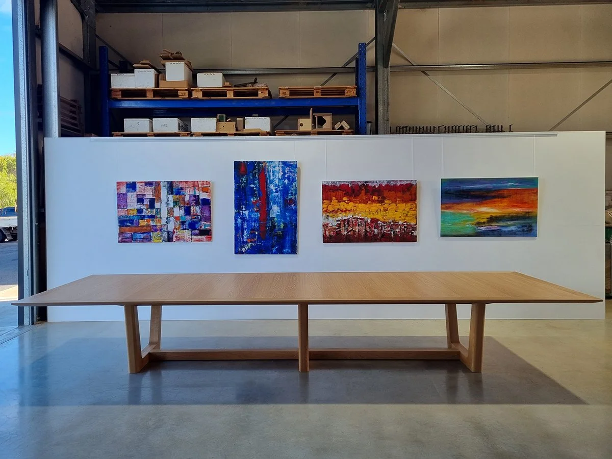 Rhodes House Boardroom Table in American Oak, trestle base design - Nathan Day Design, full front view against artwork backdrop in workshop