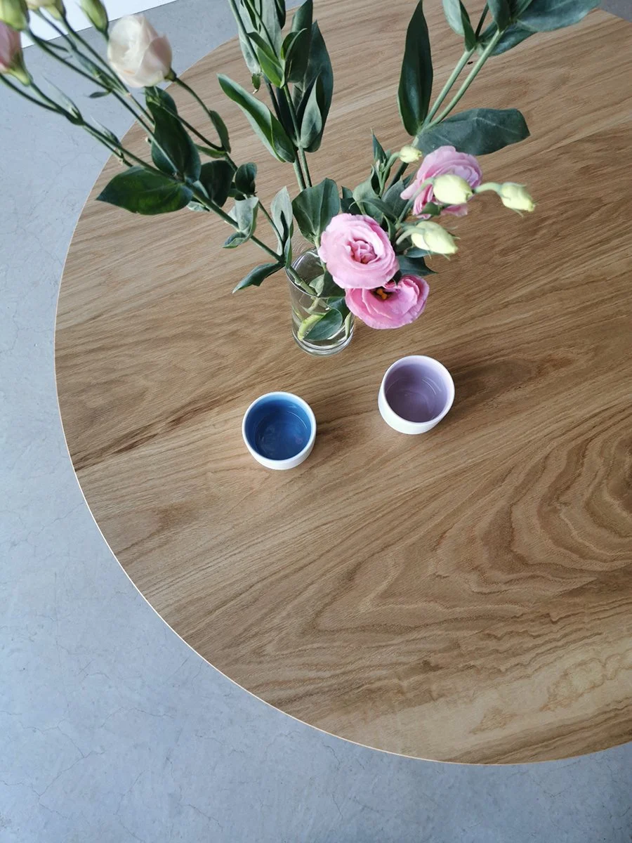 Overhead detail of the Wonton Coffee Table's American Oak grain, styled with flowers and ceramics - Nathan Day Design