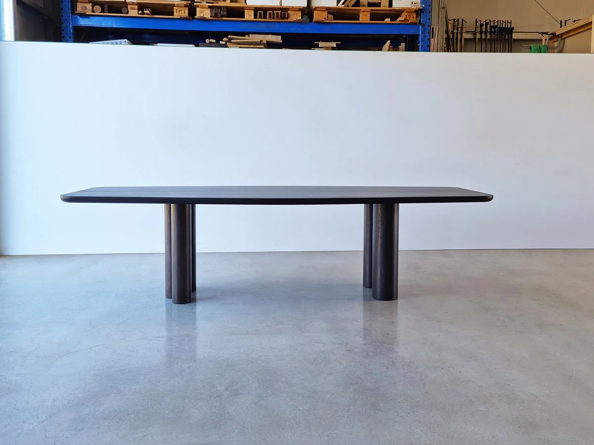 Full side profile of Column Table in Ebonised Walnut, sculptural silhouette shown in workshop setting - bespoke furniture by Nathan Day Design