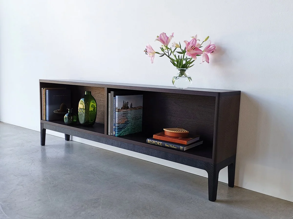 Sally's Bookcase in ebonised and scorched Jarrah, styled with lily flowers and books - Nathan Day Design bespoke furniture