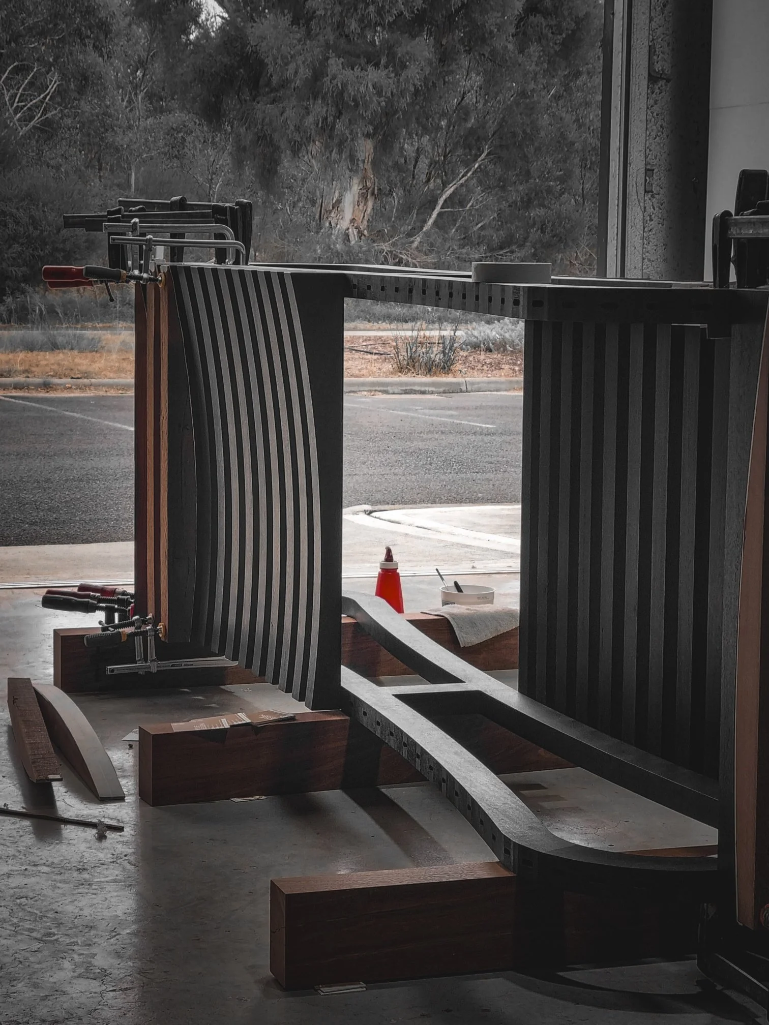 Curved fluted timber table legs being shaped in steel forming jigs at the Nathan Day Design workshop